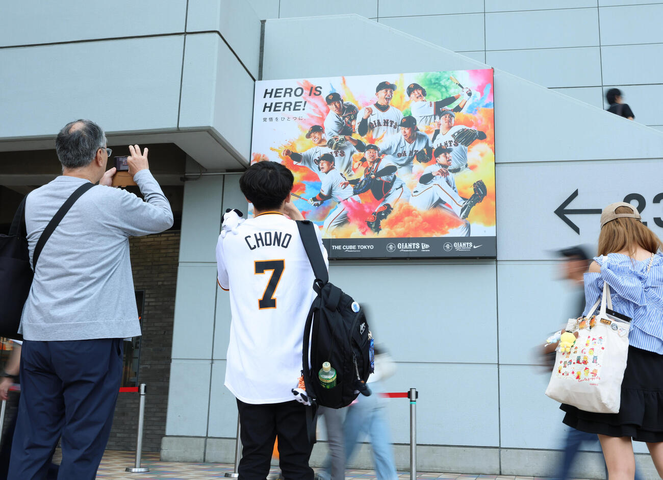 東京ドーム場外のポスターを撮影する巨人ファン（撮影・増田悦実）