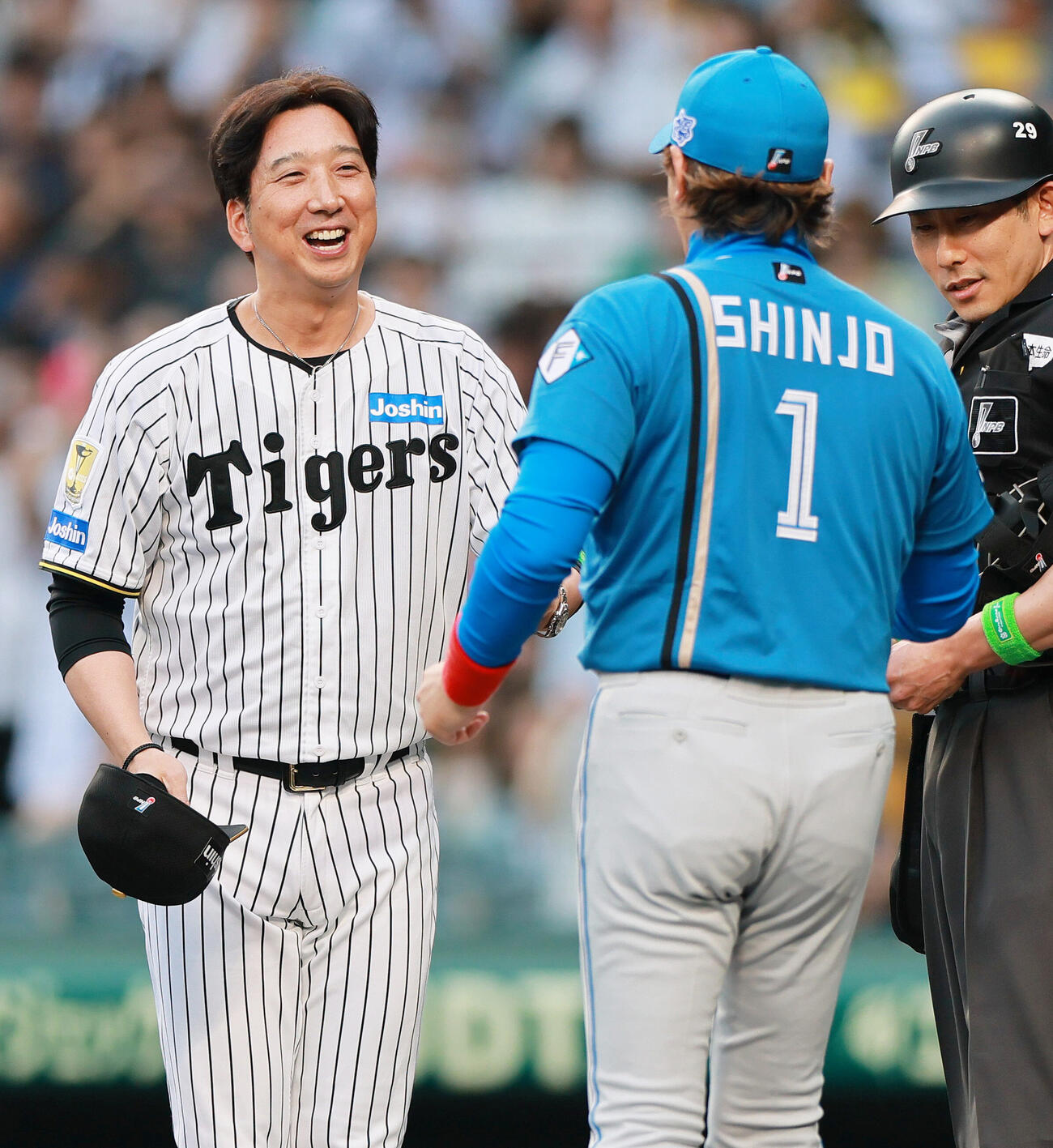 セ・パ交流戦　阪神対日本ハム1回戦　阪神対日本ハム　メンバー表の最終確認で阪神藤川球児監督は日本ハム新庄剛志監督（手前）と顔を合わせ笑顔を見せる（撮影・上山淳一）