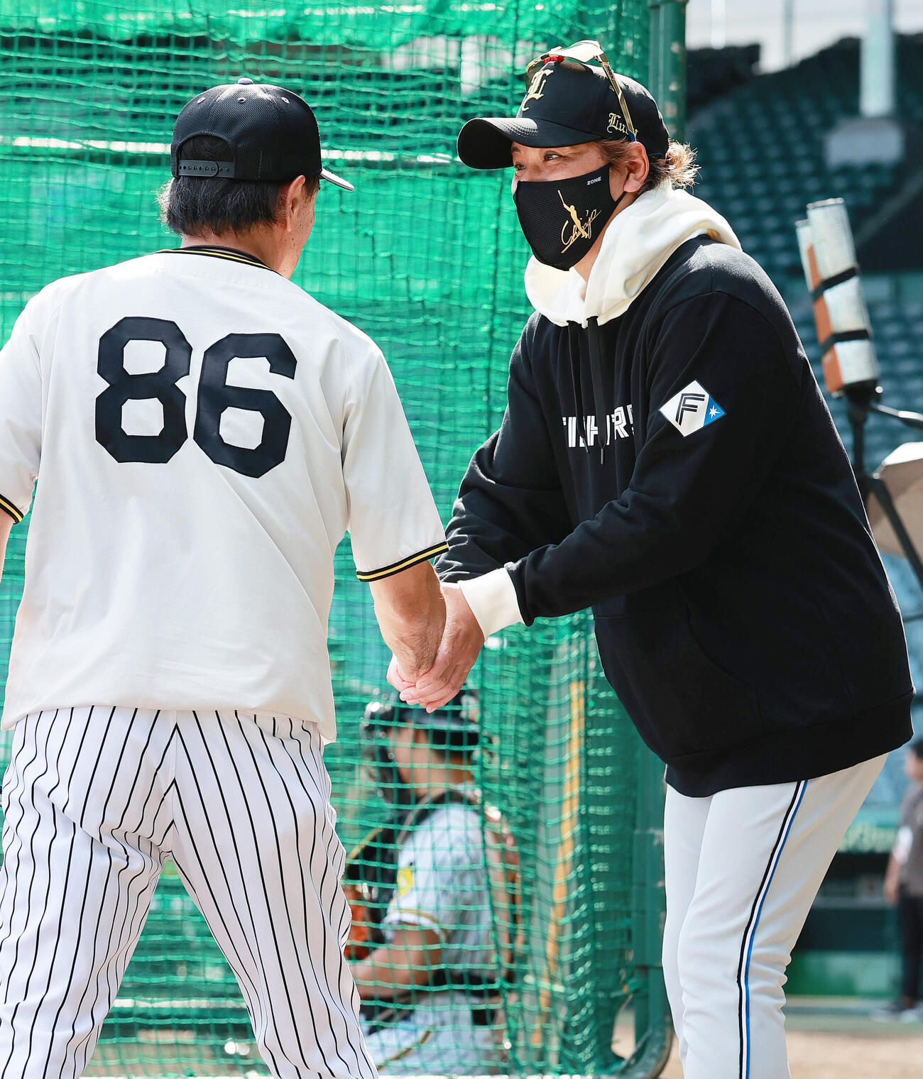セ・パ交流戦　阪神対日本ハム1回戦　阪神対日本ハム　試合前、阪神和田豊ヘッドコーチ（左）と握手をかわす日本ハム新庄剛志監督（撮影・上山淳一）