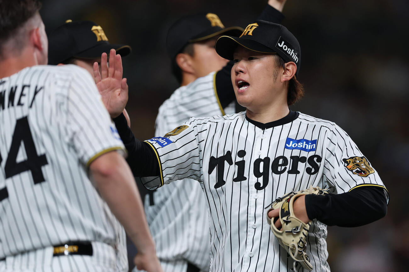 阪神対日本ハム　5回表日本ハム2死一、三塁、矢沢宏太を二ゴロに打ち取りピンチをしのぎ、ナインに迎えられる西勇輝（右）（撮影・前田充）＝2026年5月26日