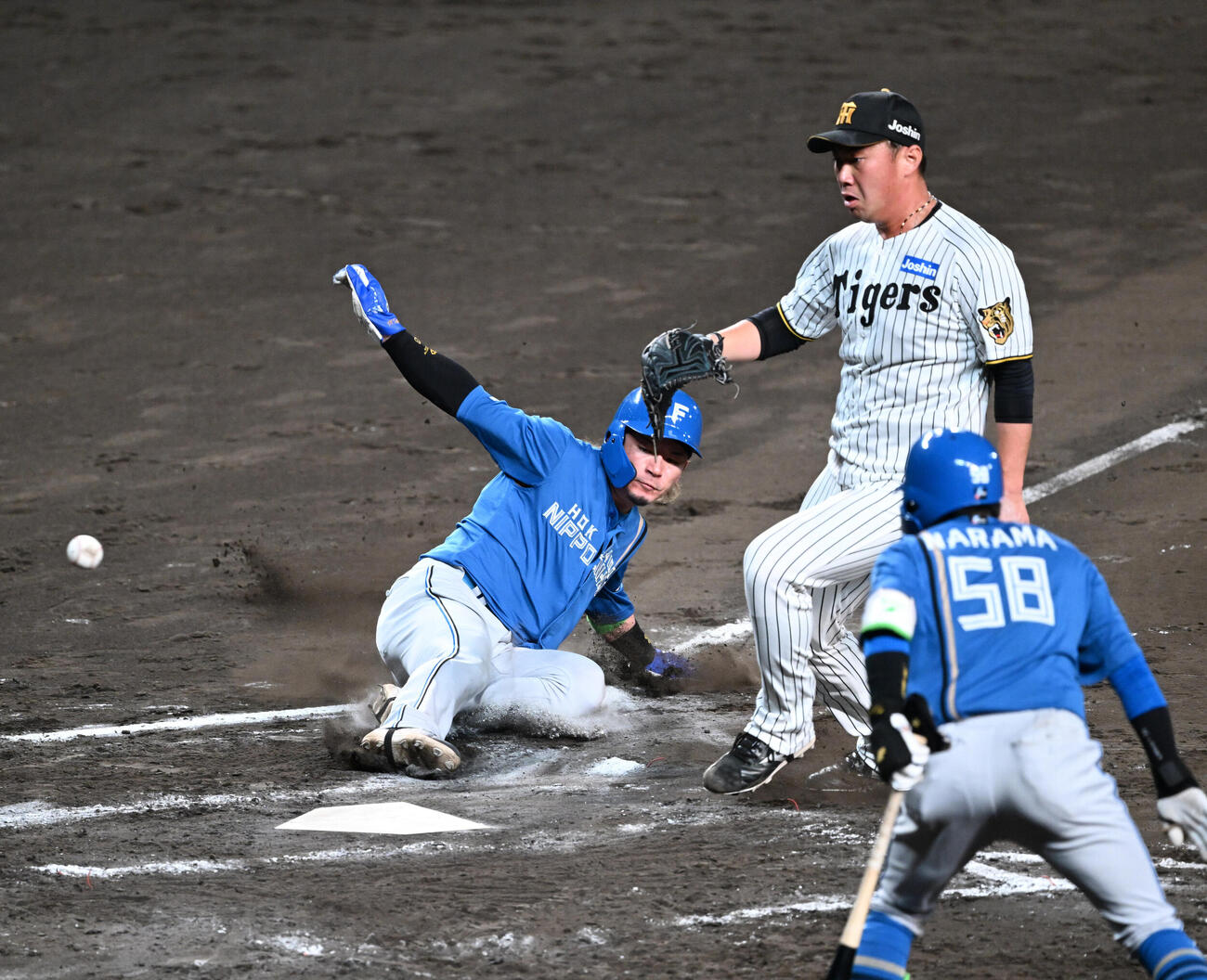 阪神対日本ハム　7回表日本ハム2死満塁、桐敷拓馬（右）の暴投で生還する三塁走者水野達稀（撮影・和賀正仁）
