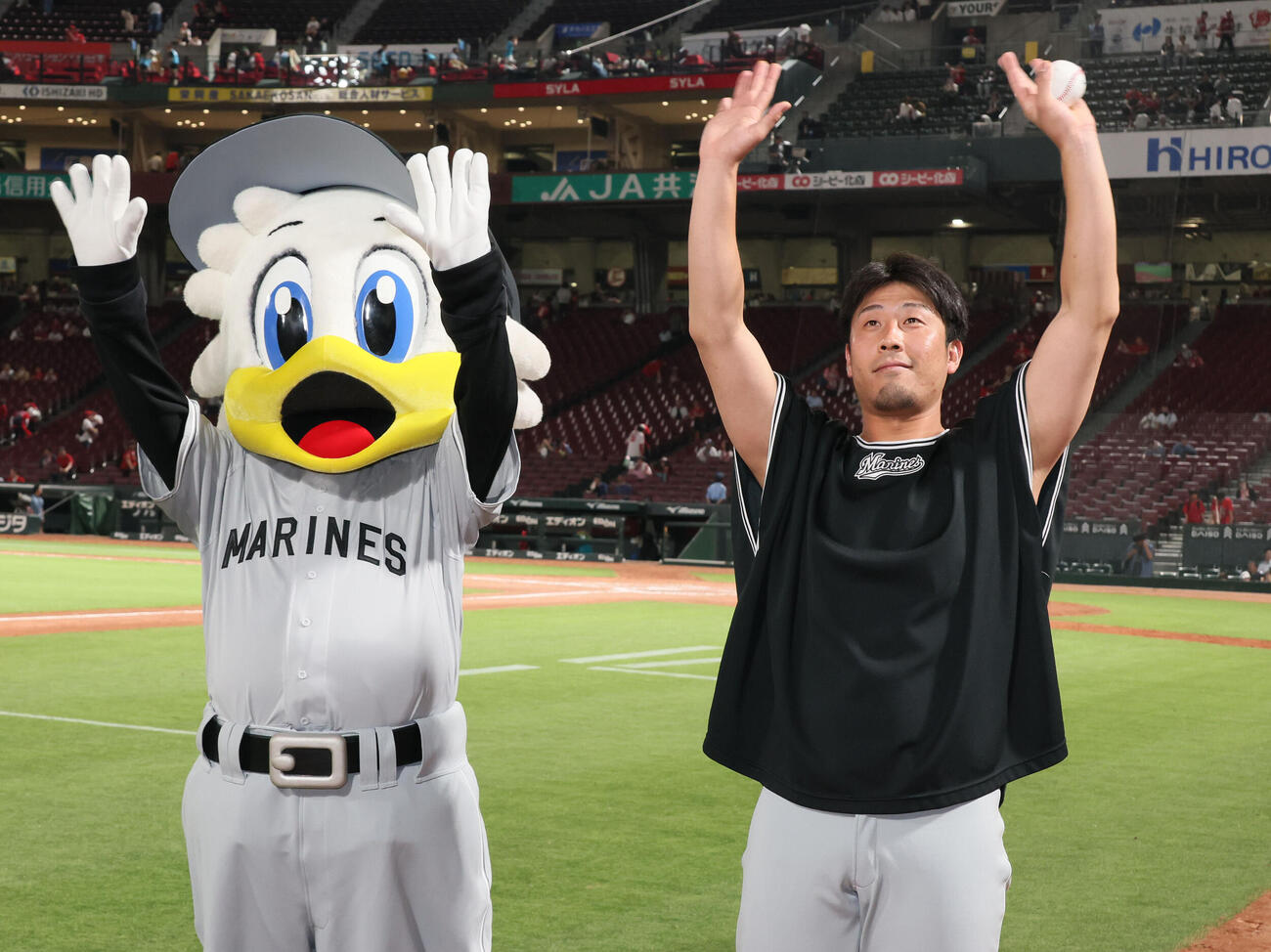 広島対ロッテ　中継ぎで5勝目をあげ、ファンの声援に応える八木彬。左はマーくん（撮影・加藤孝規）