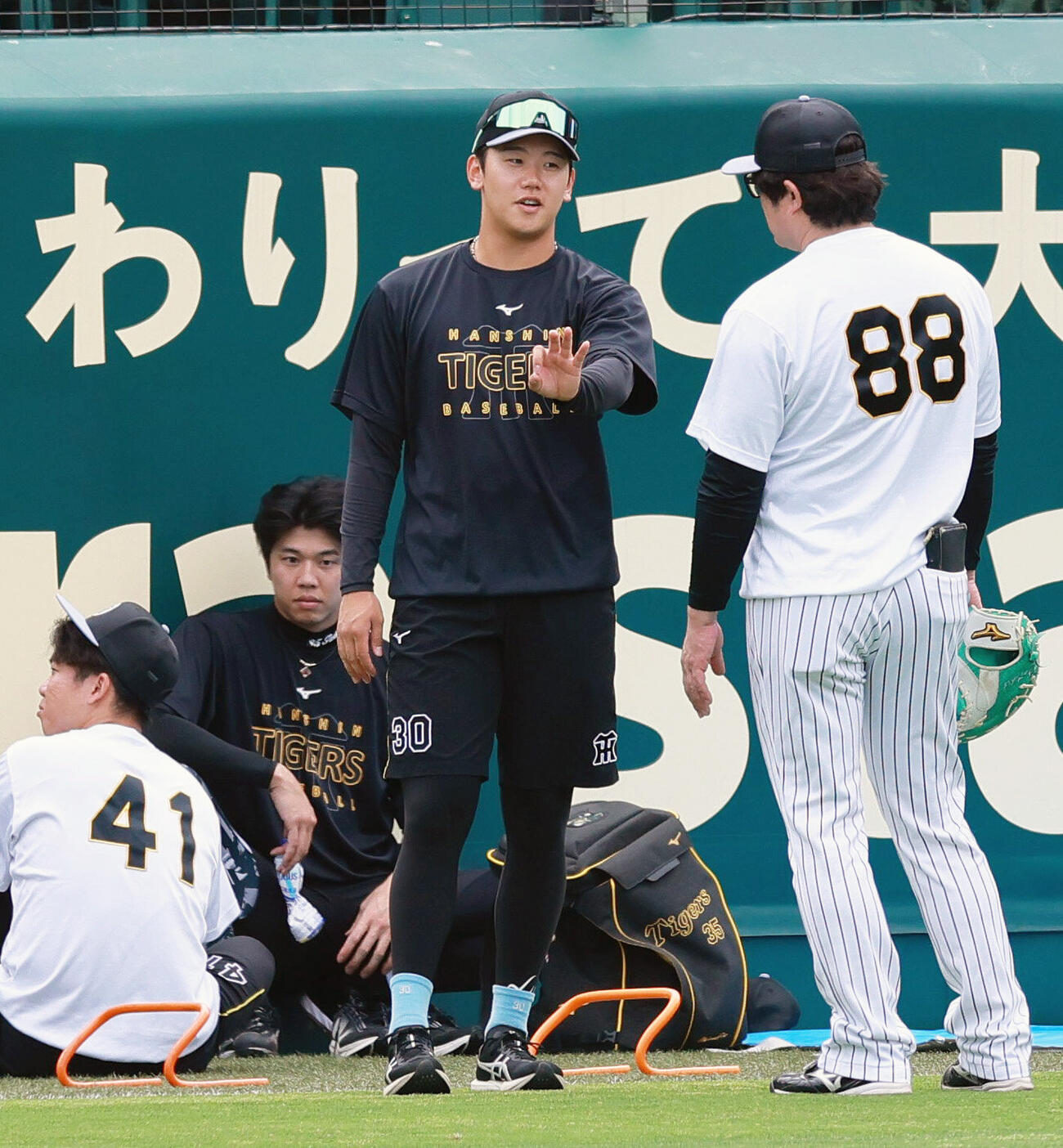 セ・パ交流戦　阪神対日本ハム2回戦　阪神対日本ハム　試合前の練習に合流した阪神門別啓人（右から2人目）は安藤優也投手チーフコーチと話す（撮影・上山淳一）