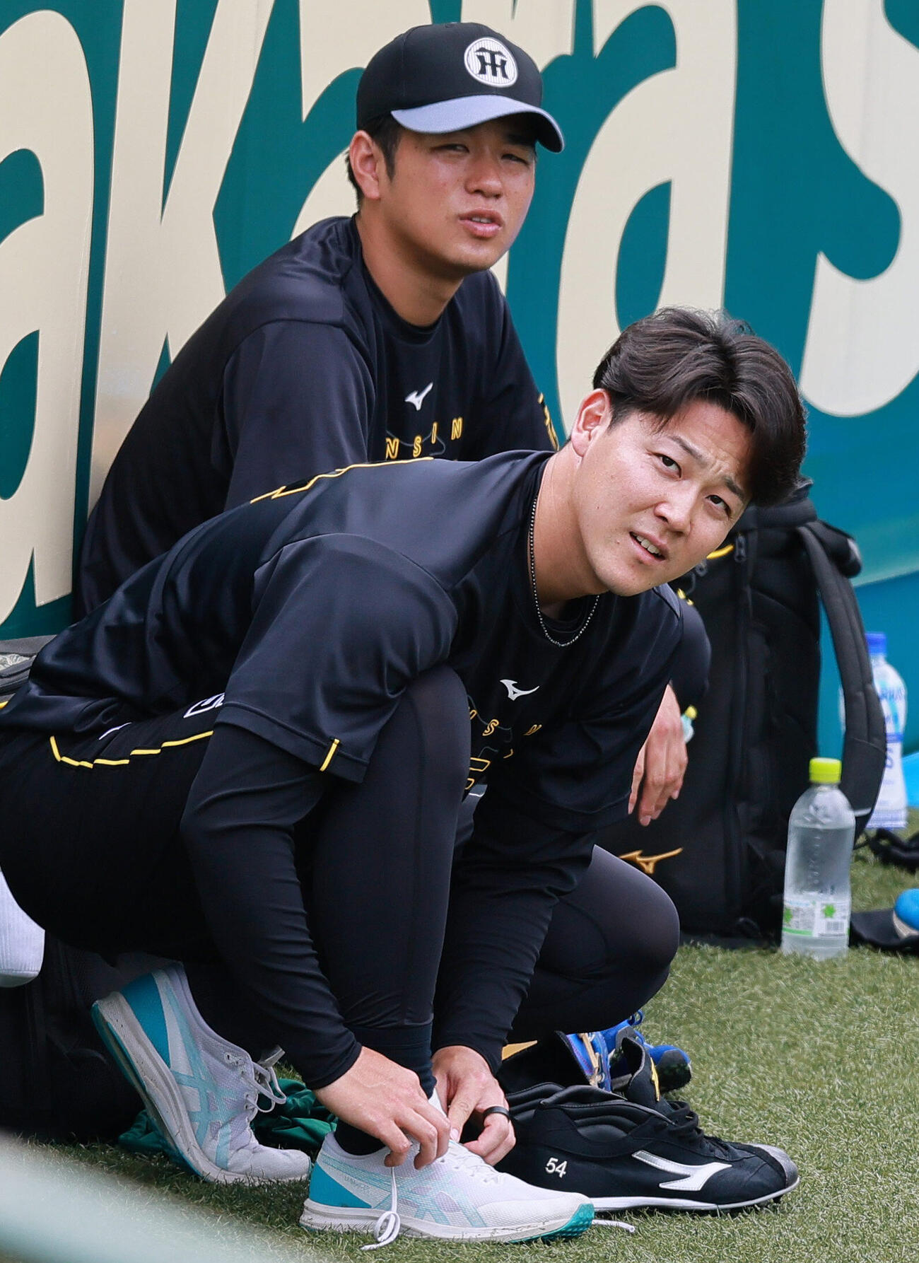 シューズを履く阪神木下里都。後方は高橋遥人（撮影・上山淳一）