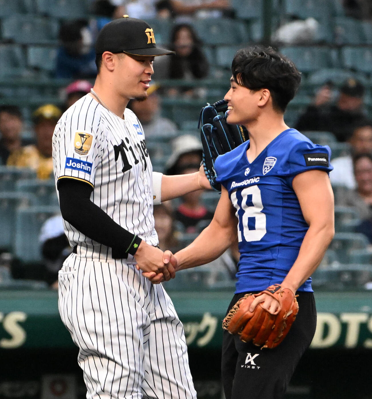 セ・パ交流戦・阪神対日本ハム2回戦　阪神対日本ハム　ファーストピッチセレモニーを務め握手をするパナソニックインパルス桑田理介（右）、阪神佐藤輝明（撮影・石井愛子）＝2026年5月27日