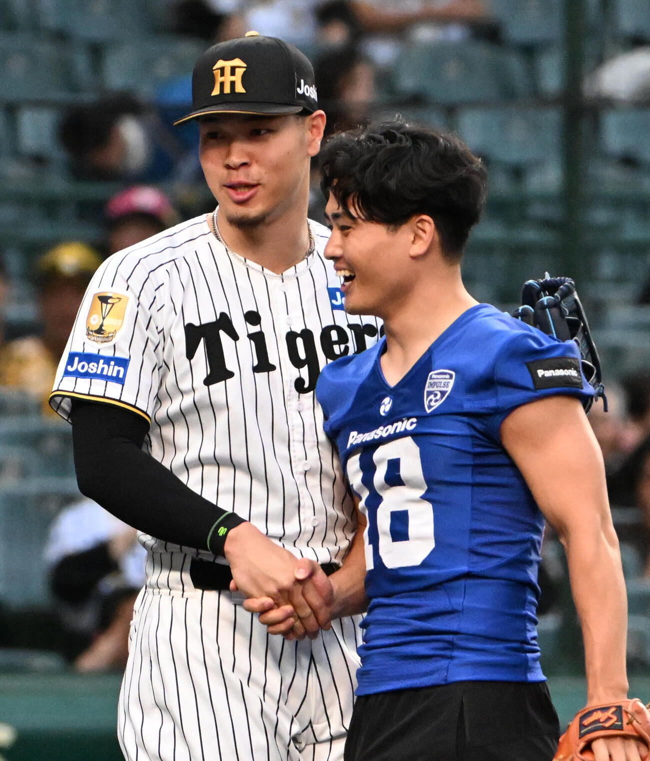 セ・パ交流戦・阪神対日本ハム2回戦　阪神対日本ハム　ファーストピッチセレモニーを務め握手をするパナソニックインパルス桑田理介（右）、阪神佐藤輝明（撮影・石井愛子）＝2026年5月27日