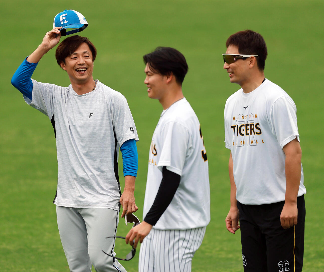 セ・パ交流戦　阪神対日本ハム2回戦　阪神対日本ハム　試合前、日本ハム島本浩也（左）と談笑する阪神岩崎優。中央は阪神及川雅貴（撮影・上山淳一）