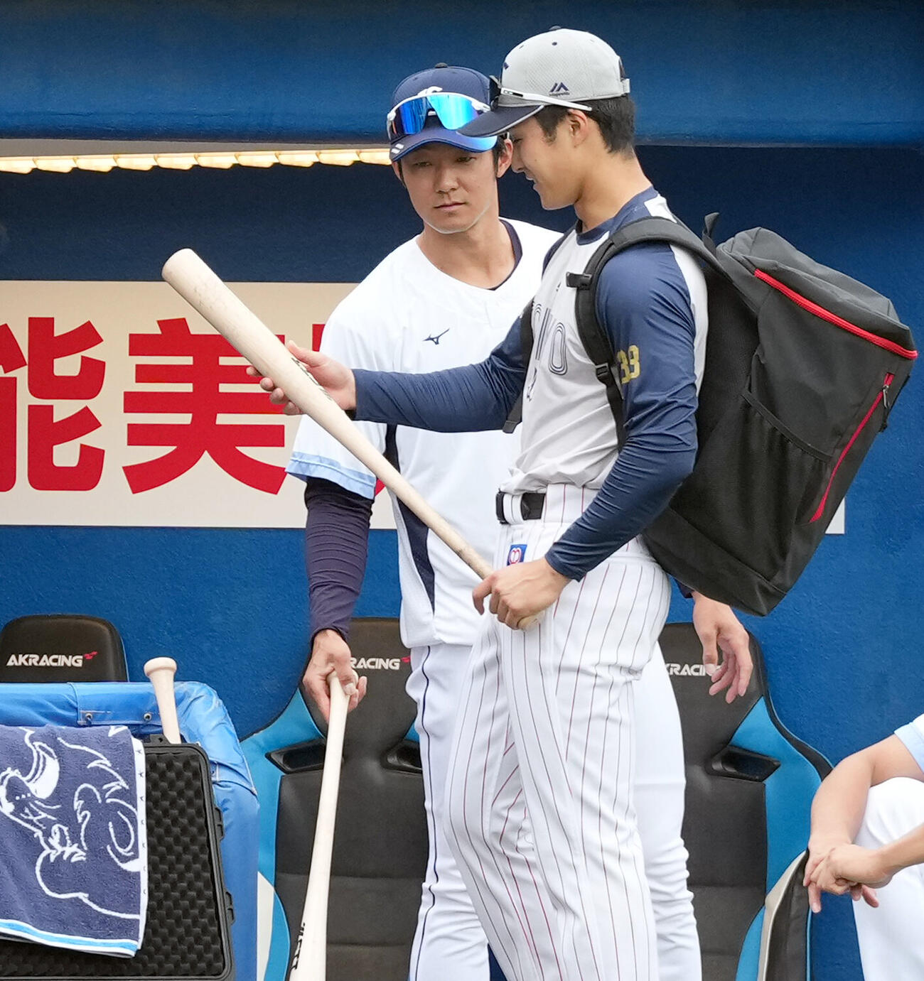 ヤクルト対西武兄で西武の石井一成のバットを見る弟のヤクルト石井巧（右）（撮影・たえ見朱実）