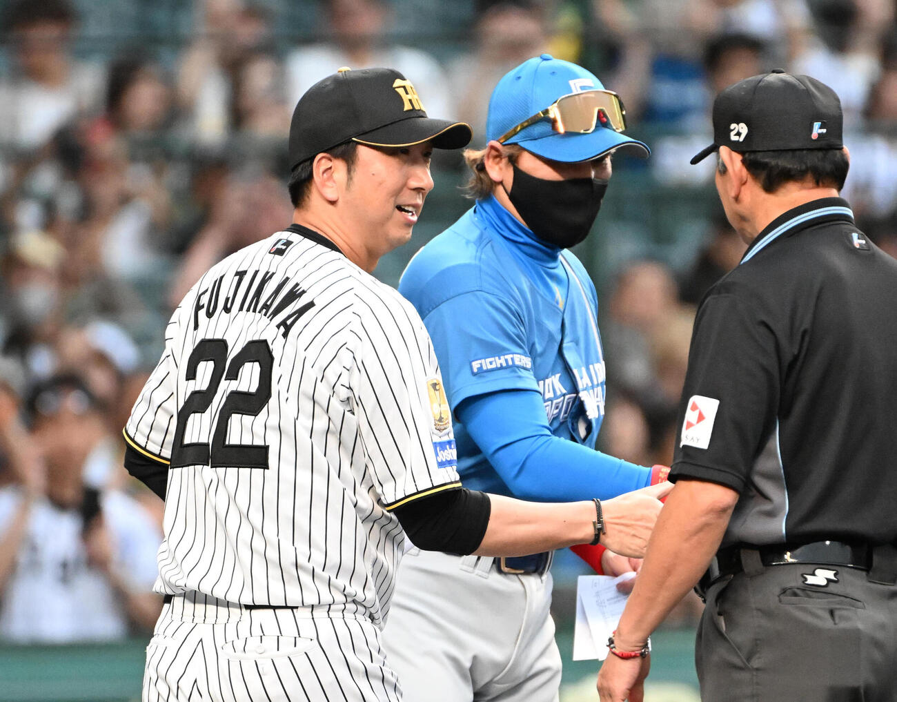 メンバー表交換をし審判と握手をする阪神藤川球児監督（左）、日本ハム新庄剛志監督（中央）（撮影・石井愛子）