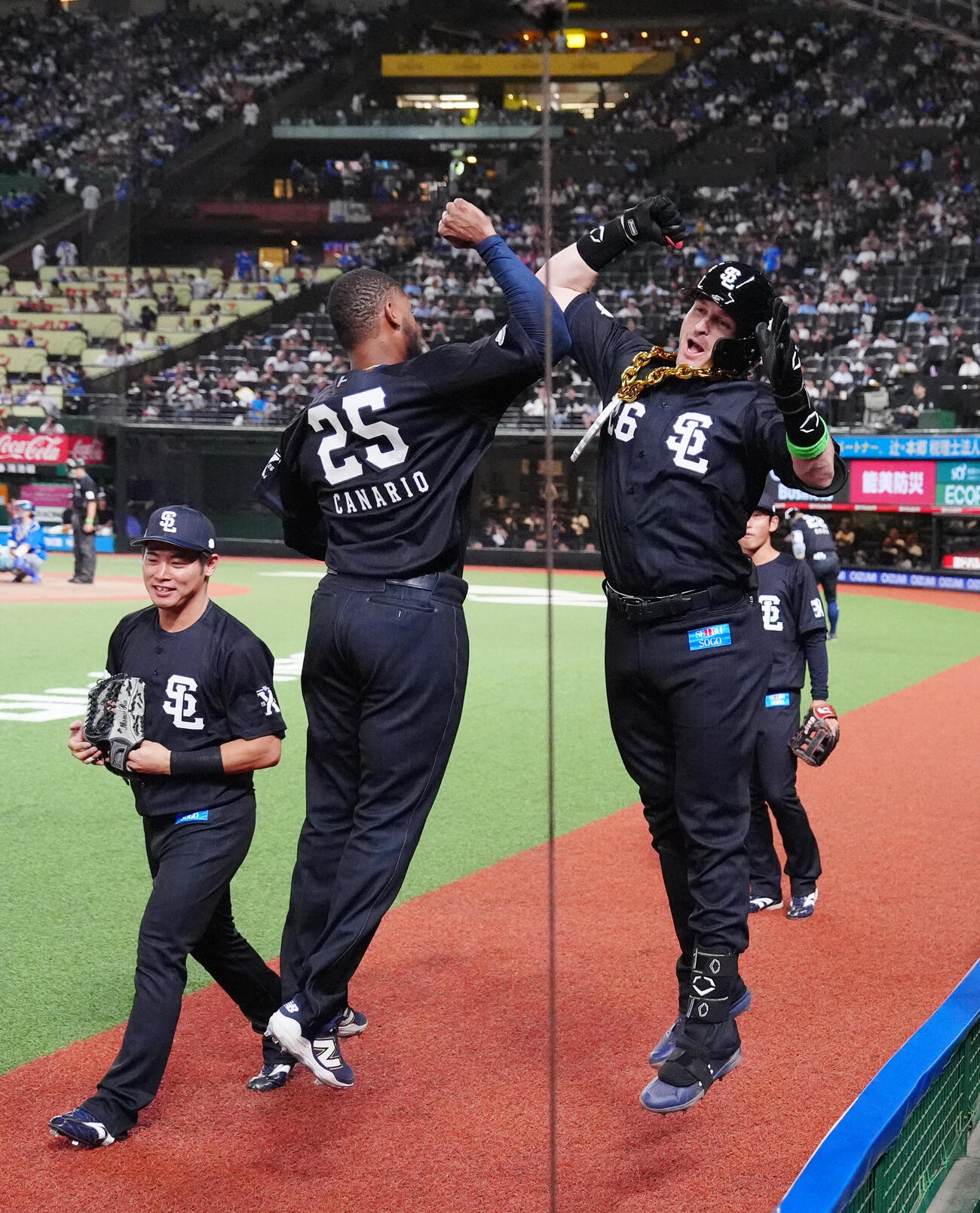 交流戦　西武対DeNA 7回裏西武1死、本塁打を放ちアレクサンダー・カナリオ（中央）とタッチを交わすタイラー・ネビン（撮影・江口和貴）＝2026年5月29日