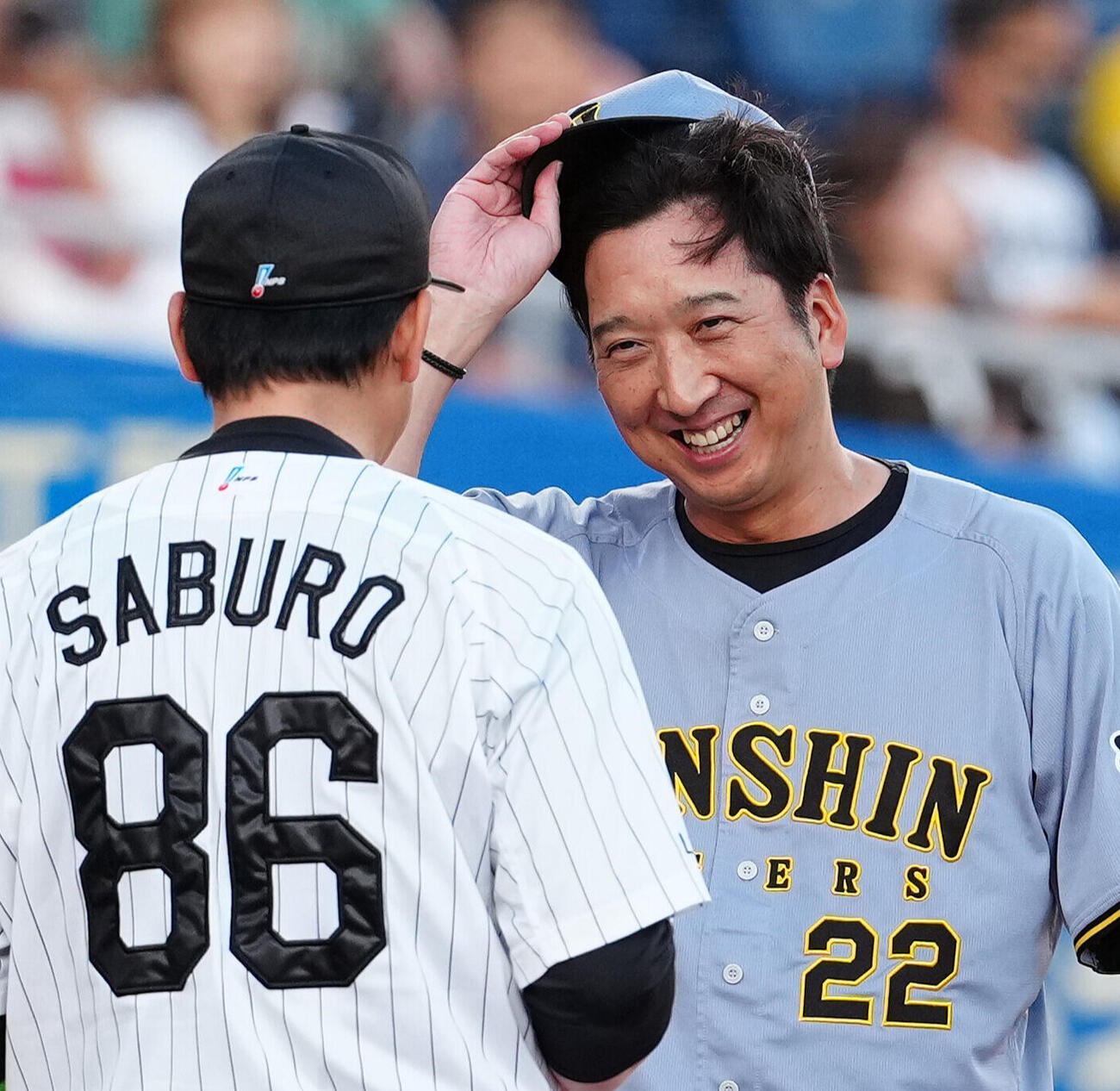 ロッテ対阪神　メンバー表の最終確認で言葉を交わす阪神藤川球児監督（右）とロッテのサブロー監督（2026年5月29日）