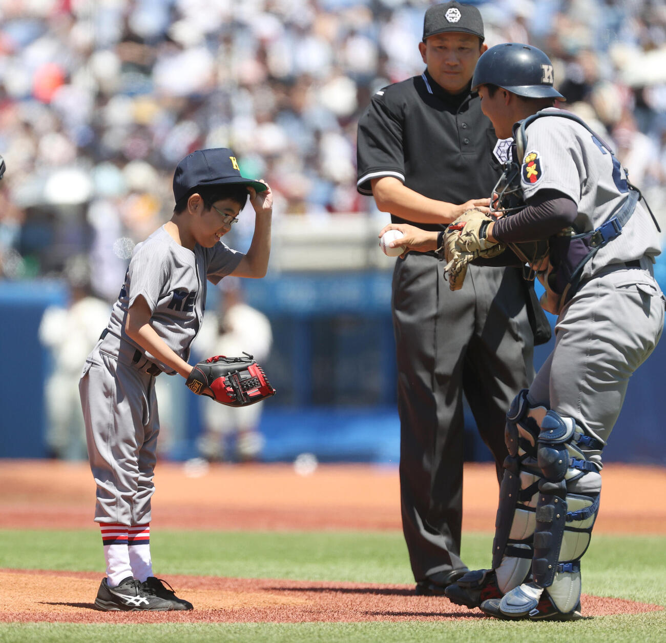 6大学野球　早大対慶大戦で始球式を務めた慶大野球部の草間実月君(左)は慶大・吉開鉄朗捕手からボールを受け取る（撮影・柴田隆二）