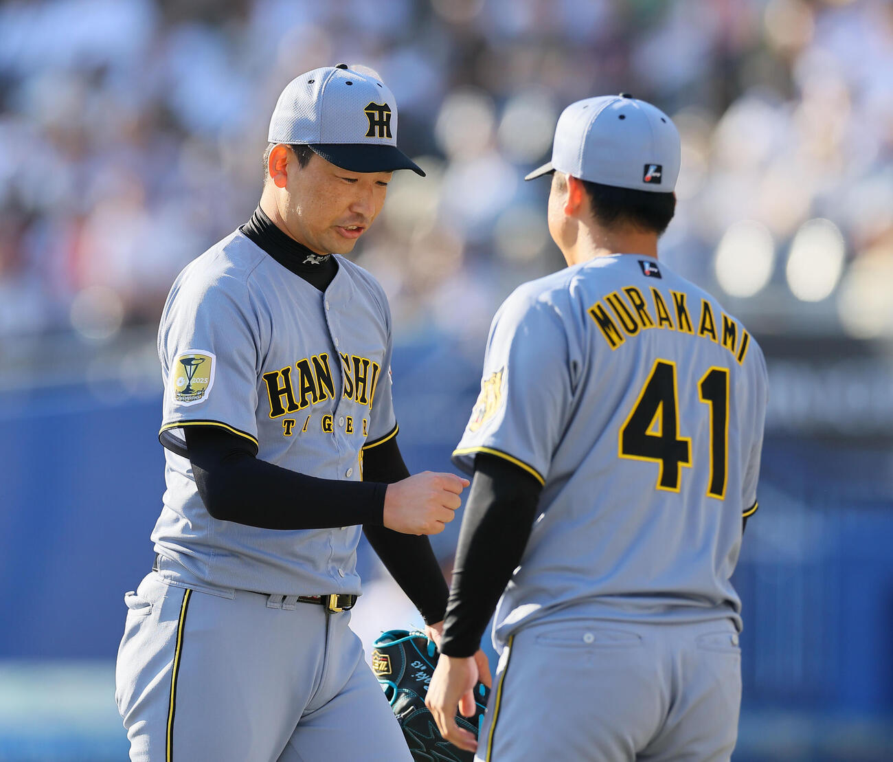 ロッテ対阪　8回途中から登板し、ピンチをしのぎ村上頌樹（右）とタッチを交わす阪神岩崎優（撮影・藤尾明華）