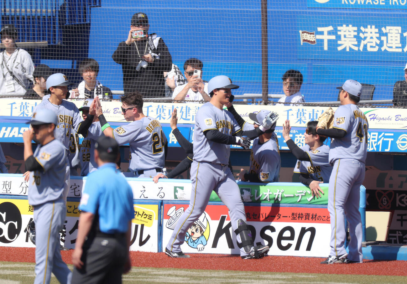 ロッテ対阪神　3回表阪神2死一塁、左越え2点本塁打で生還し、チームメートに迎えられる森下翔太（中央）（撮影・河田真司）