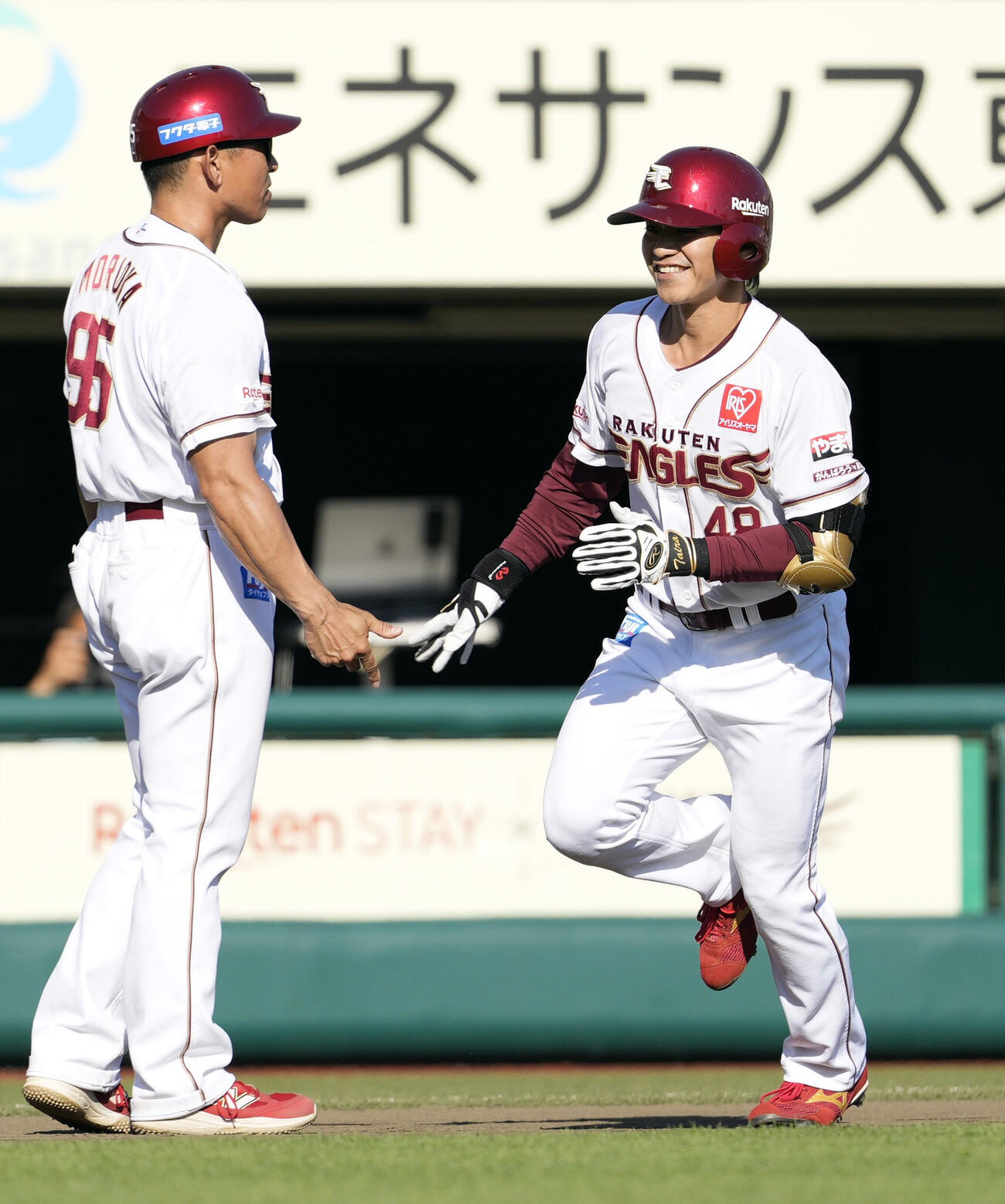 7回、本塁打を放ち三塁コーチとタッチを交わす楽天・平良（共同）