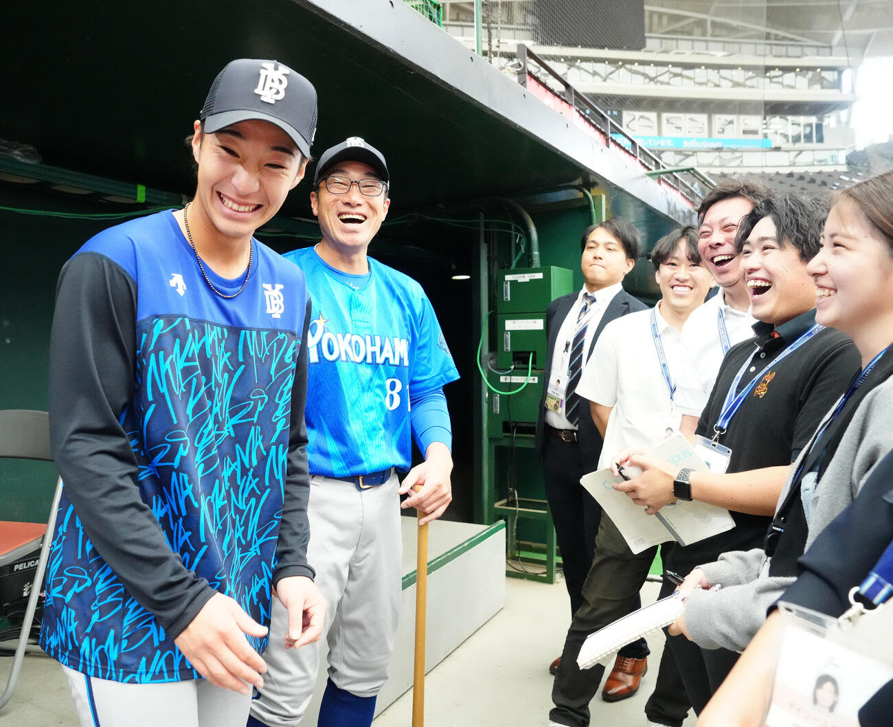 交流戦　西武対DeNA　試合前のDeNA相川亮二監督（左から2人目）の囲み取材に同席しようとし、笑顔を見せる度会隆輝（撮影・江口和貴）