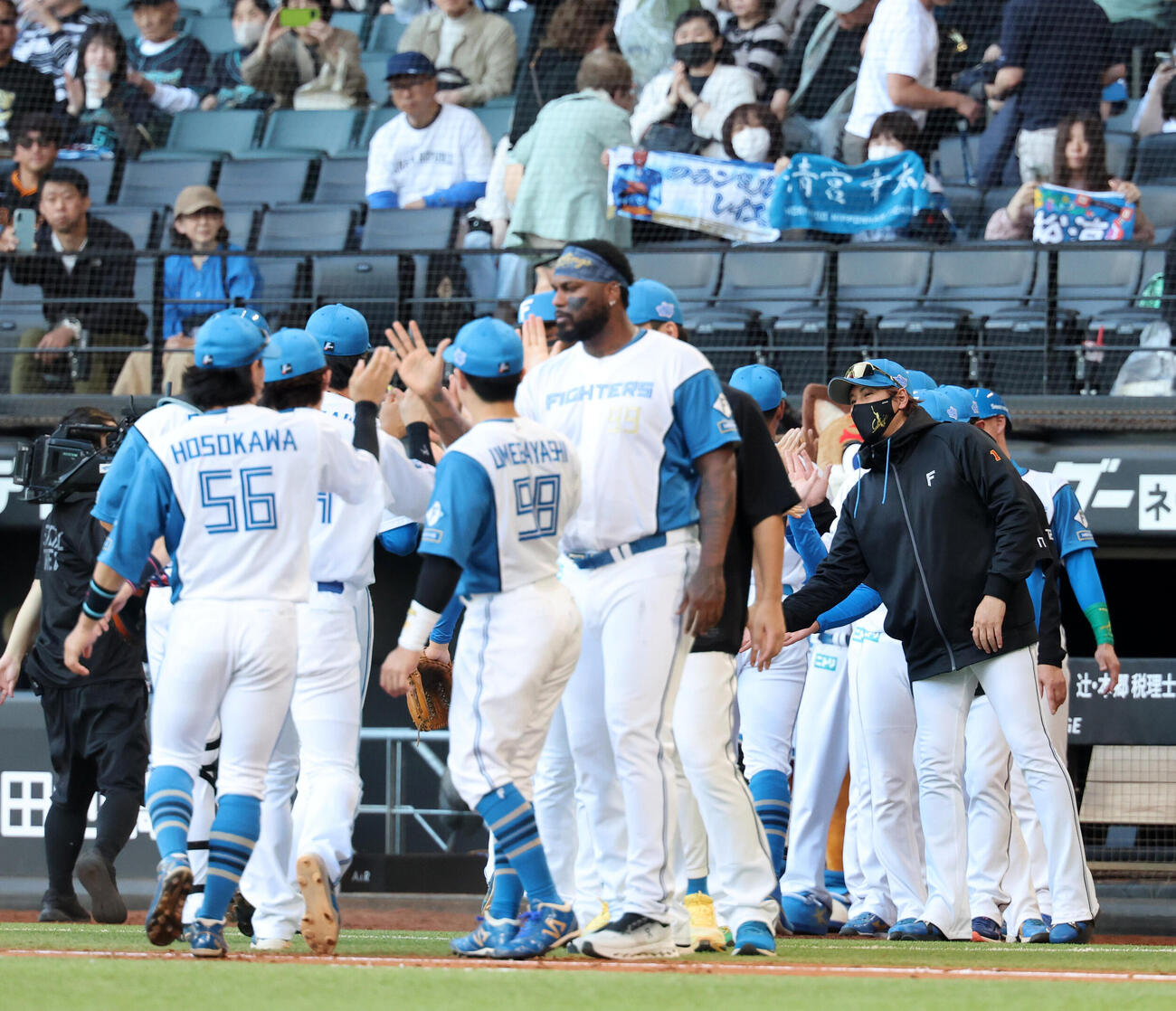 日本ハム対巨人　連敗ストップでハイタッチで迎える日本ハム新庄剛志監督（右）（撮影・浅見桂子）