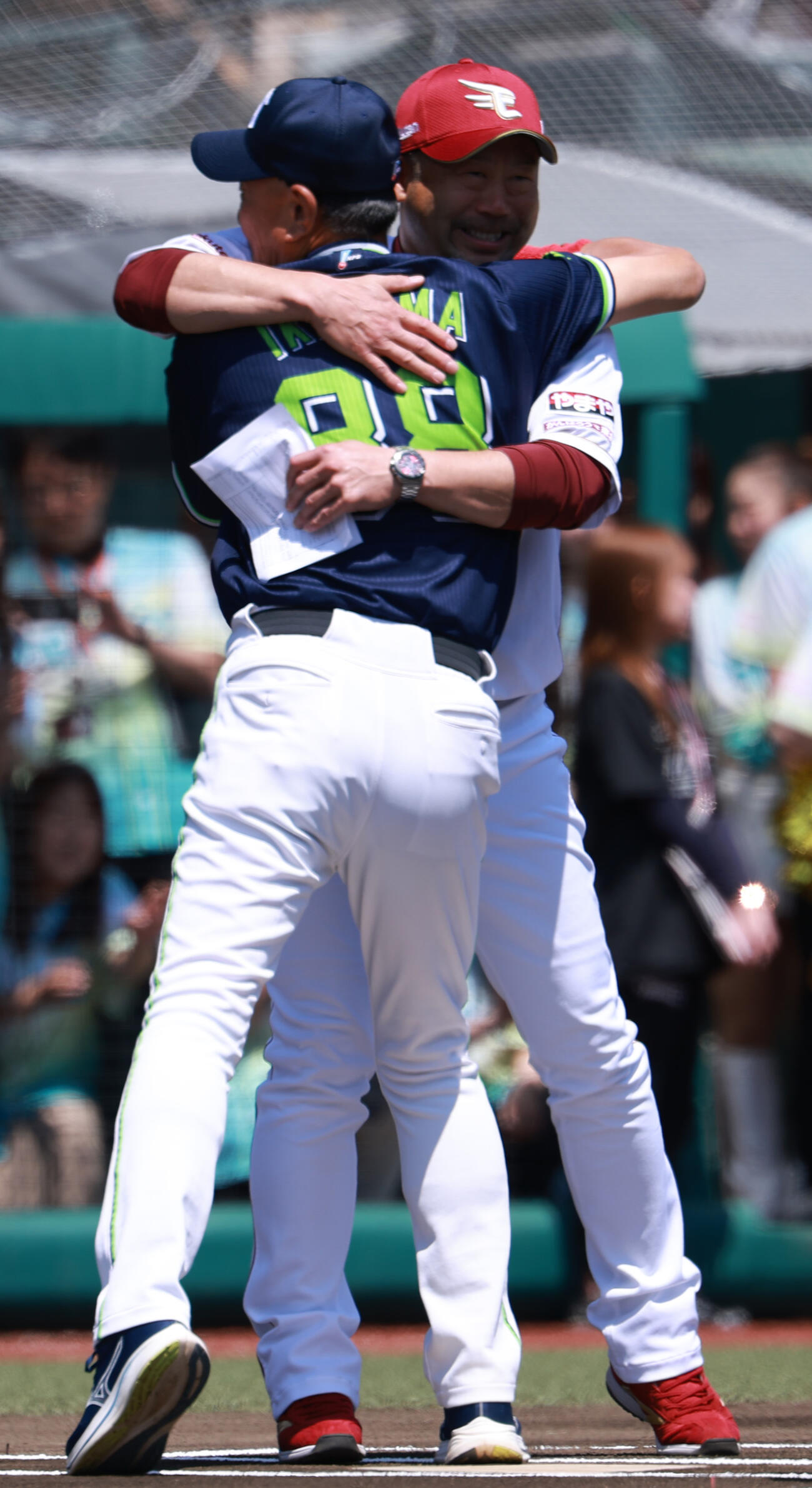 交流戦　楽天対ヤクルト　メンバー表の交換でハグするヤクルト池山隆寛監督（左）と楽天三木肇監督（撮影・水谷安孝）＝2026年5月31日