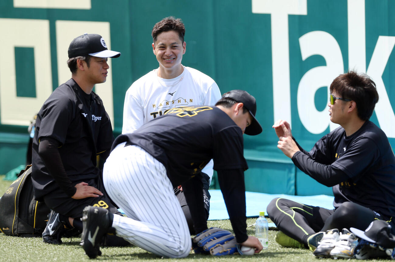 練習の合間に笑顔を見せる阪神大竹耕太郎（左から2人目）。左は高橋遥人、右は西勇輝、手前は木下里都（撮影・前田充）