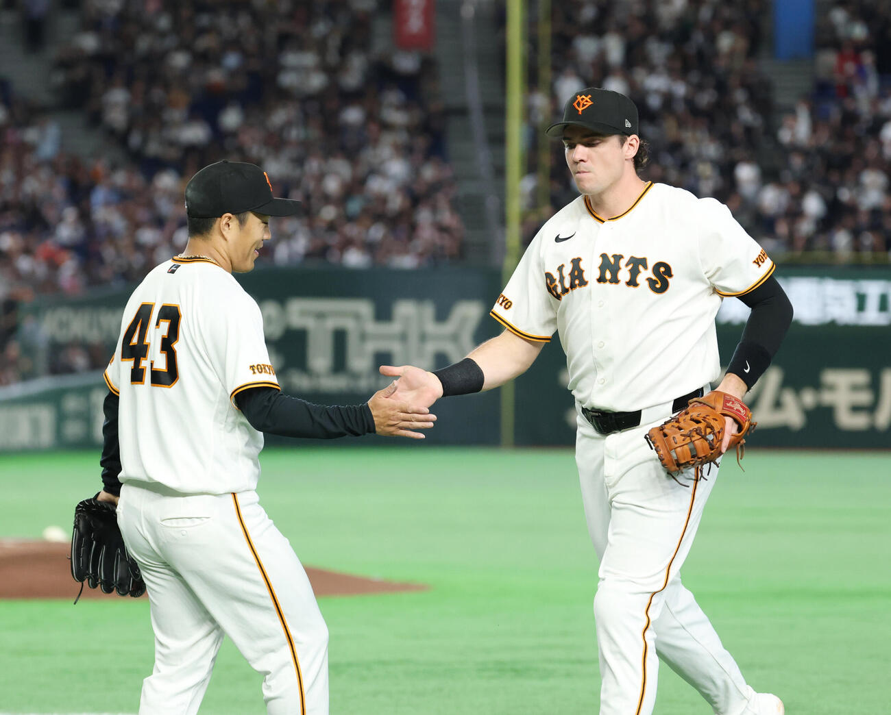 巨人対オリックス　5回表を終え好守備をしたボビー・ダルベック（右）とタッチを交わす則本昂大（撮影・増田悦実）