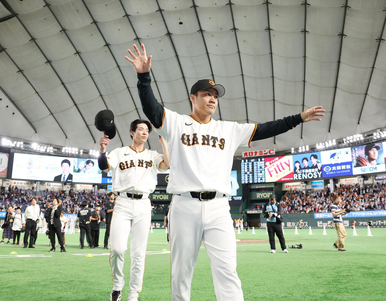 巨人対オリックス　ファンに手を振りながら引き揚げる巨人則本昂大（手前）と松本剛（撮影・増田悦実）