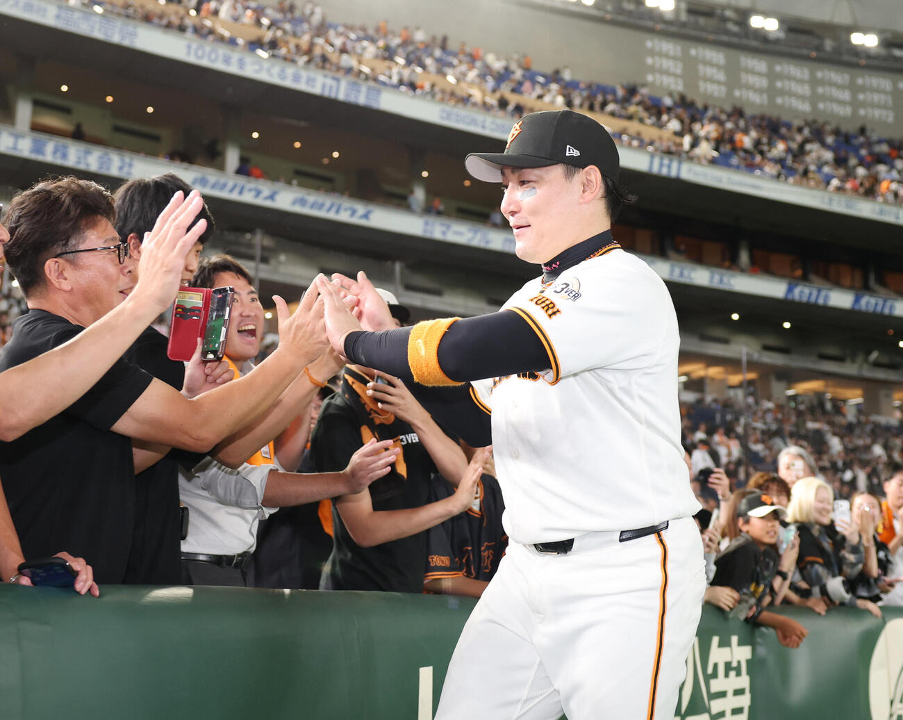 巨人対オリックス　逆転満塁本塁打を放ちファンとタッチを交わす丸佳浩（撮影・増田悦実）