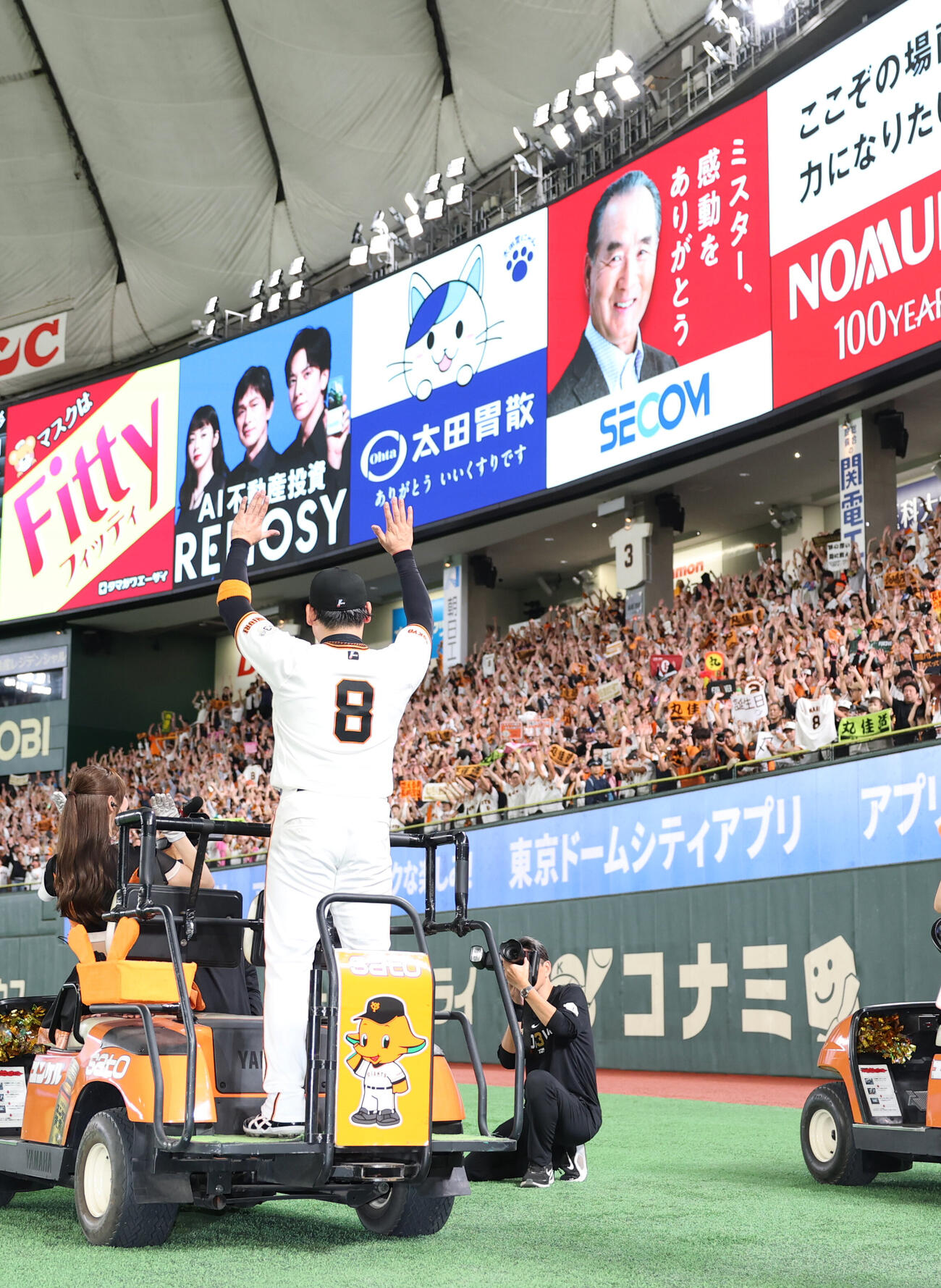 巨人対オリックス　長嶋茂雄氏の看板の前でファンと万歳をする丸佳浩（撮影・増田悦実）