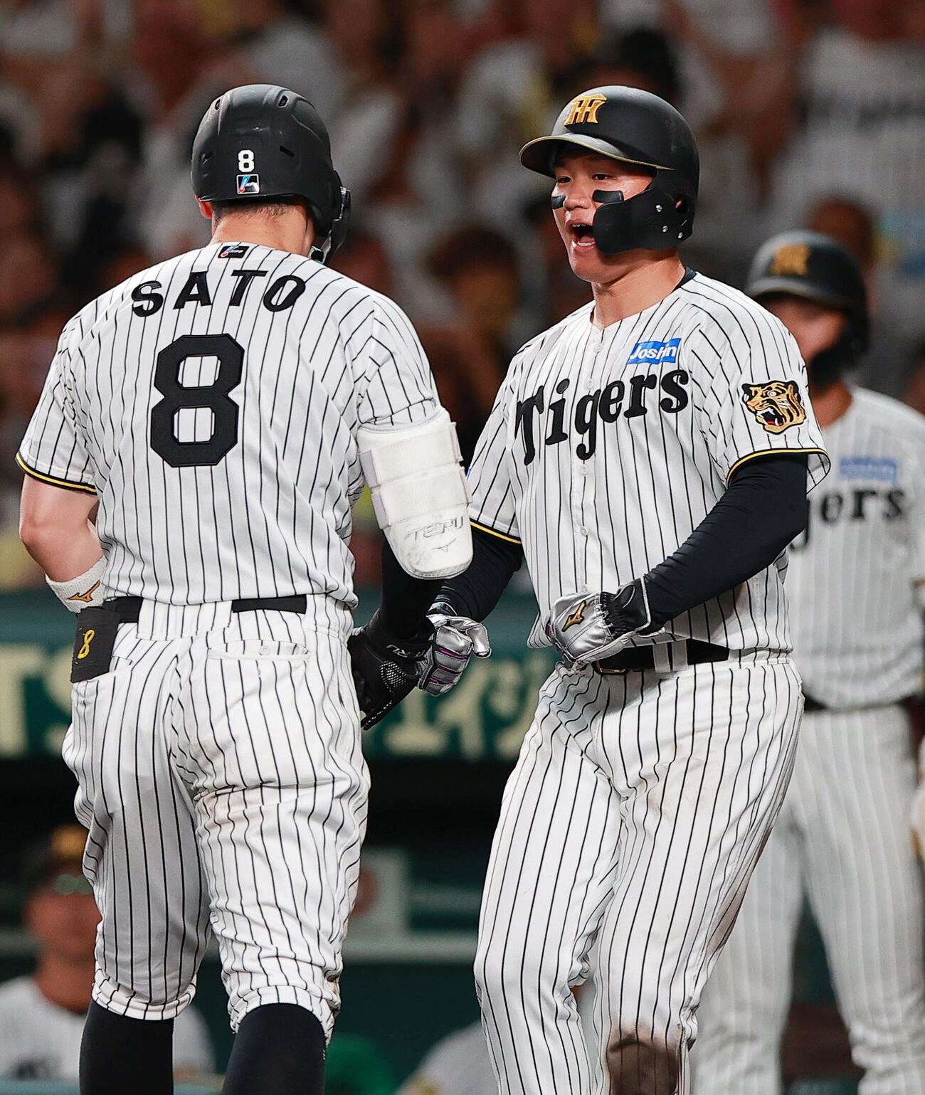 阪神対西武　9回裏阪神無死三塁、2点本塁打を放った佐藤輝明（手前）を出迎える三走森下翔太（撮影・上山淳一）