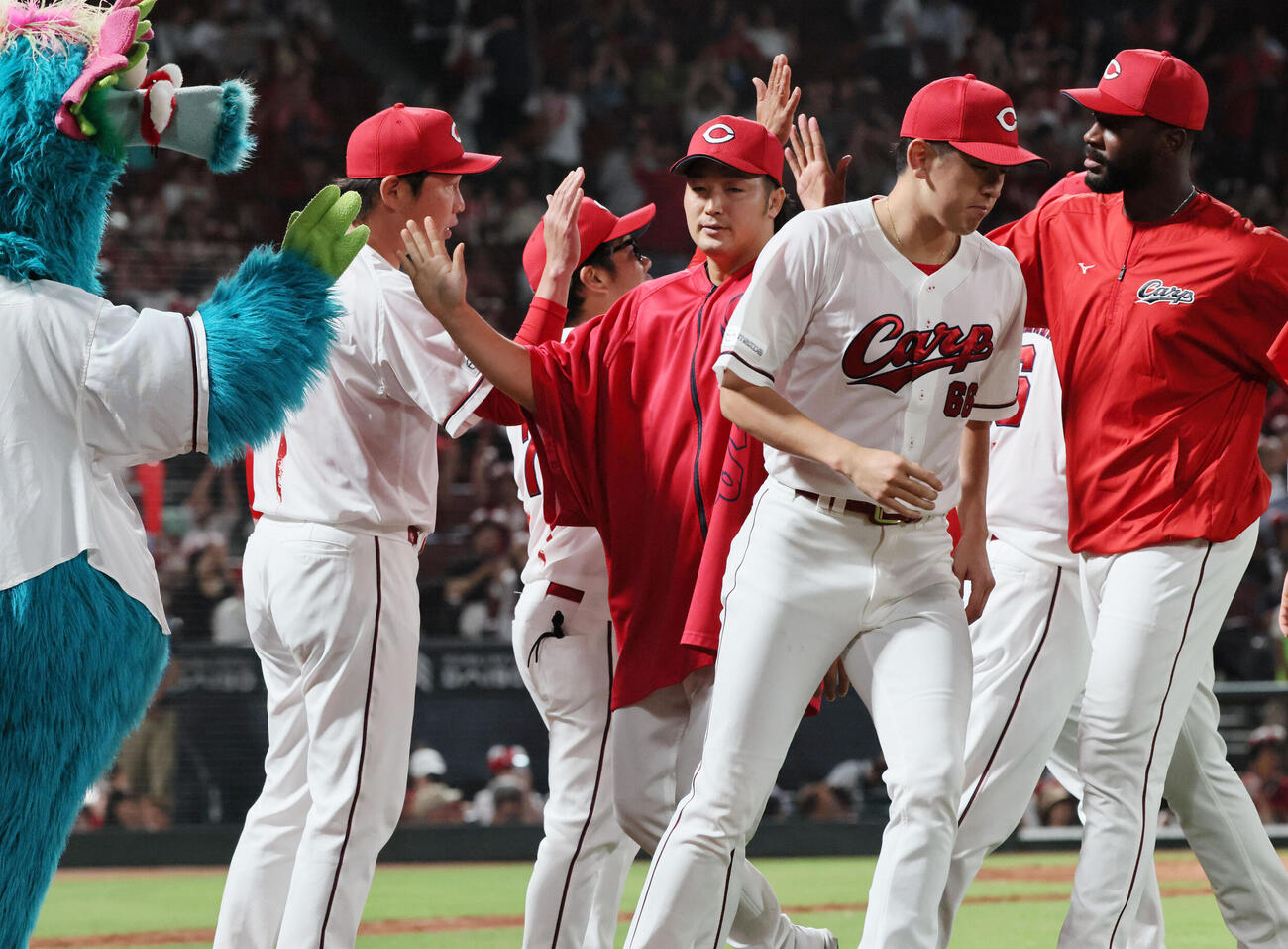 広島対日本ハム　交流戦初勝利の広島ナインを迎える新井貴浩監督。中央は床田寛樹（撮影・加藤孝規）