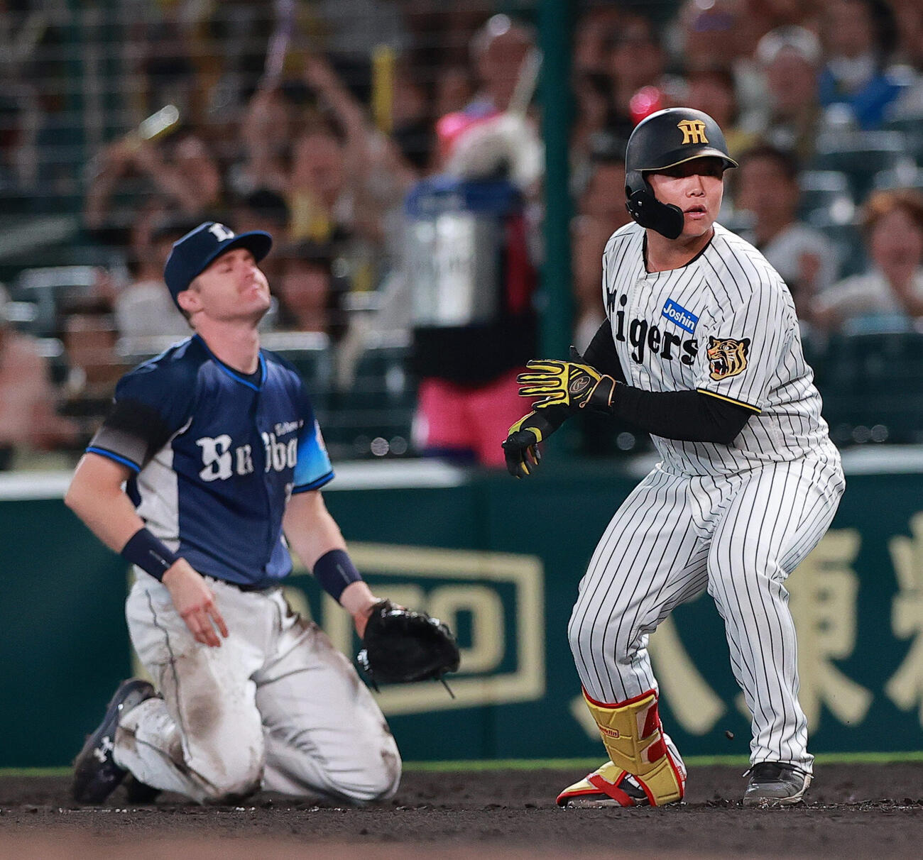 阪神対西武　8回裏阪神2死、代打嶋村麟士朗は一塁内野安打を放つ。左は一塁手タイラー・ネビン（撮影・上山淳一）