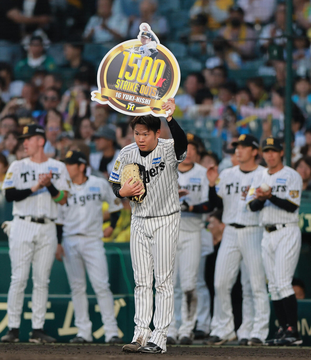 阪神対西武　通算1500奪三振を記録し、記念ボードを手にスタンドの声援に応える阪神西勇輝（撮影・上山淳一）