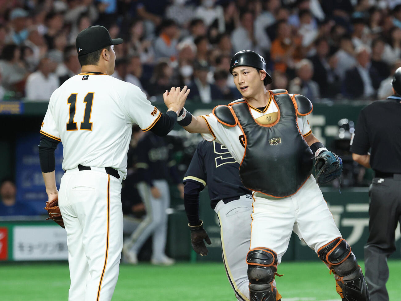 巨人対オリックス　4回表オリックス2死一塁、山中稜真の生還を阻止しタッチを交わす田中将大（左）と小林誠司（撮影・増田悦実）