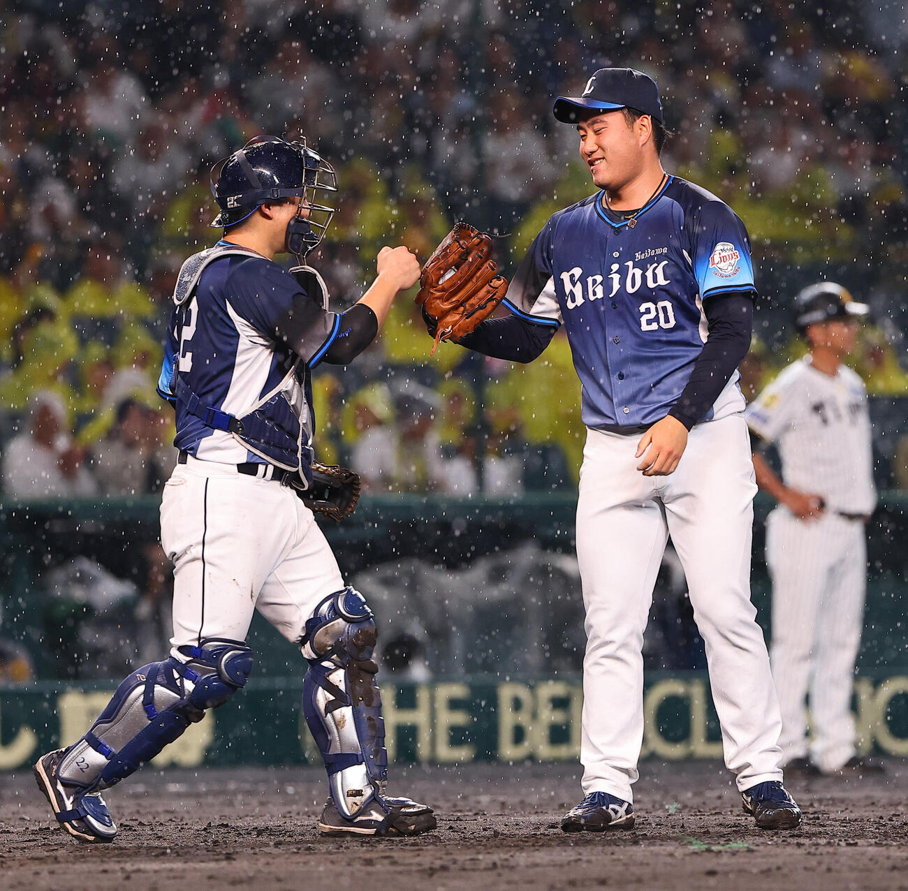 阪神対西武　セーブを上げた岩城颯空（右）は古賀悠斗とグラブタッチをする（撮影・上田博志）