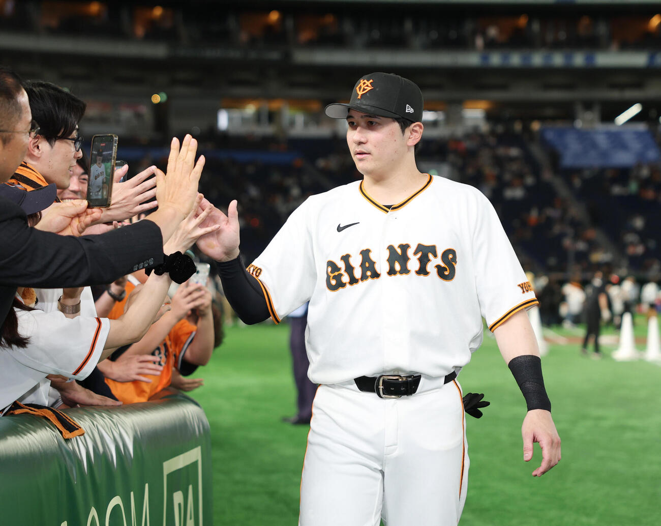 巨人対オリックス　ヒーローとなりファンとタッチを交わす泉口友汰（撮影・増田悦実）