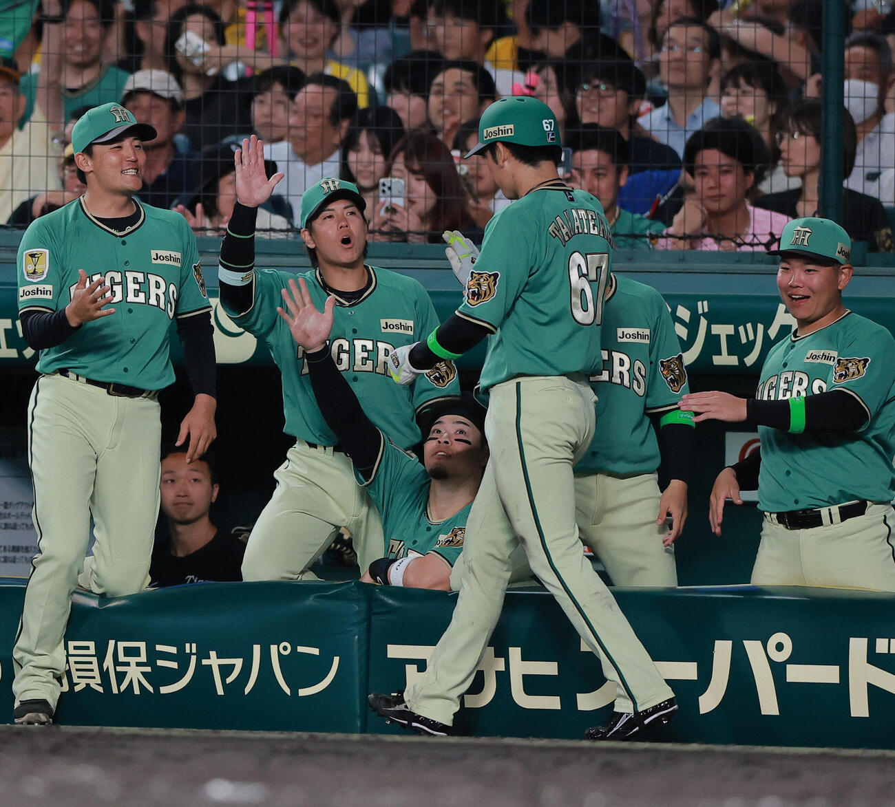 阪神対楽天　6回裏阪神1死三塁、三走高寺望夢（手前）は熊谷敬宥の適時打で生還し、祝福を受ける（撮影・上山淳一）