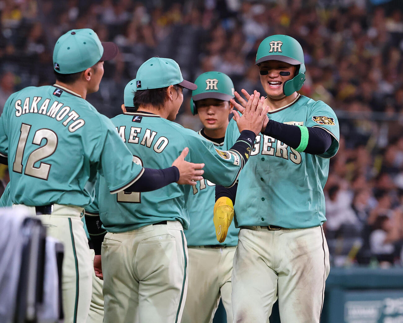 阪神対楽天　5回裏阪神2死一、二塁、佐藤輝明の2点適時二塁打で生還した森下翔太（右）と高橋遥人はナインの出迎えを受ける（撮影・上田博志）
