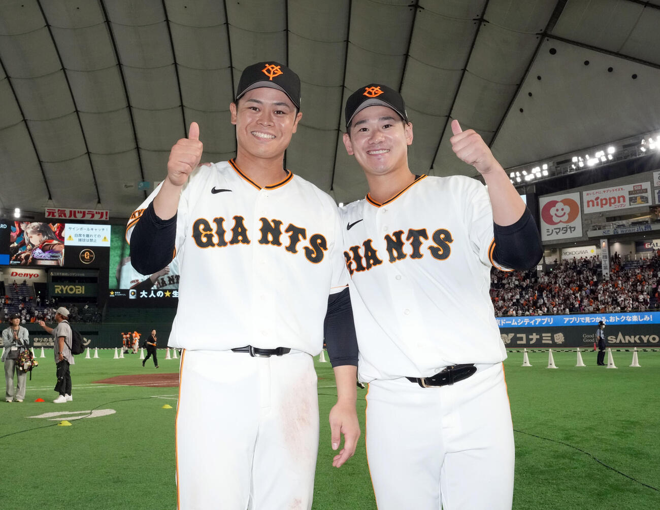 巨人対ロッテ　ロッテに勝利しカメラに向かって笑顔を見せる巨人中山礼都（左）と井上温大（撮影・たえ見朱実）