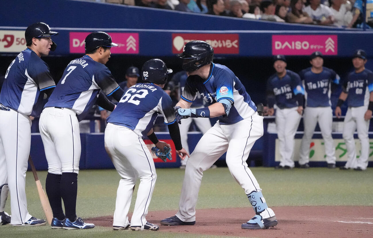 プロ野球交流戦中日対西武　6回表西武2死一、三塁、タイラー・ネビン（右）は3点本塁打を放ち生還しナインとタッチを交わす（撮影・森本幸一）