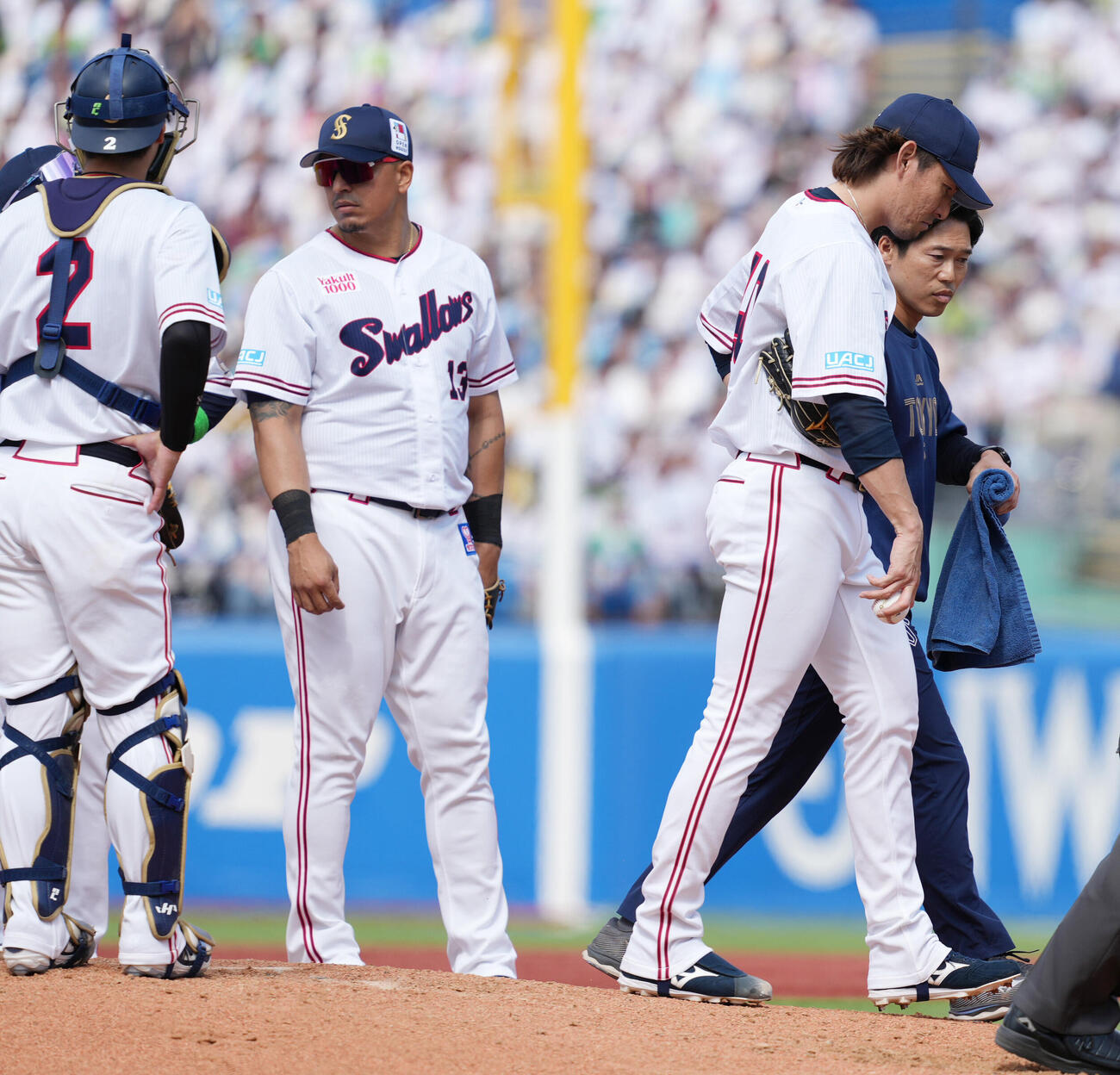 ヤクルト対日本ハム　4回表日本ハム1死二、三塁、トレーナーといっしょにベンチへ引き揚げるヤクルト先発の高梨裕稔（右）（撮影・小沢裕）　