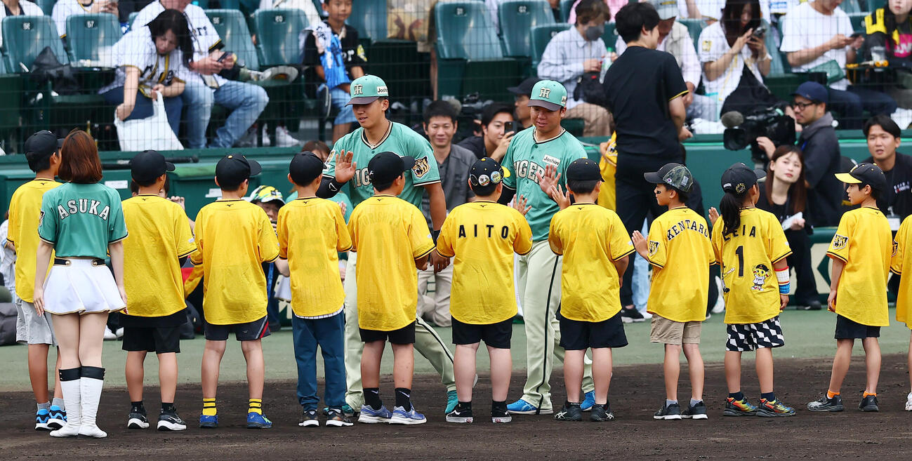 阪神対楽天　楽天に勝利しファンクラブの子どもたちとタッチする阪神立石正広（左）、村上頌樹（撮影・加藤哉）