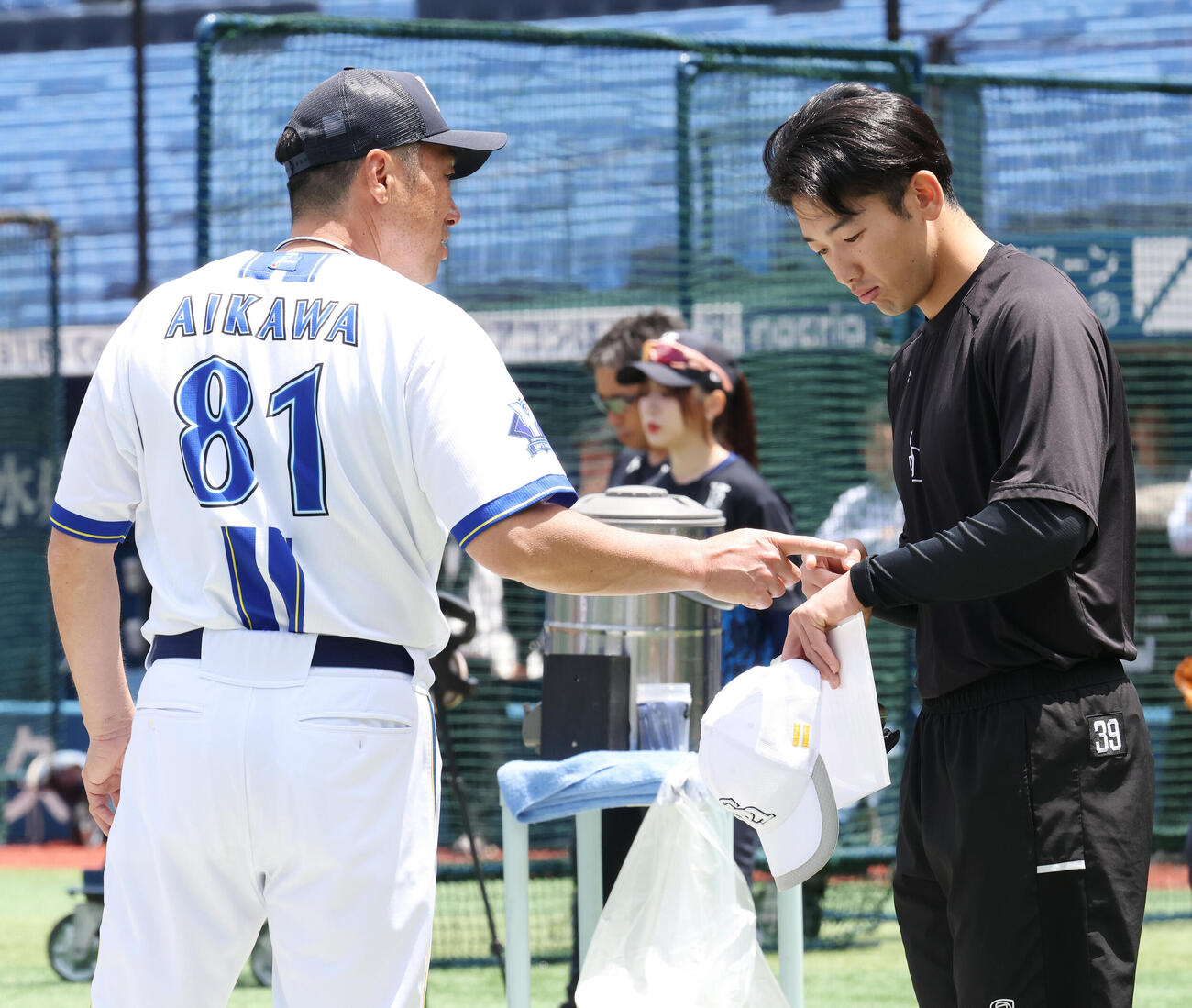 DeNA対ソフトバンク　試合前、ソフトバンク山本祐大（右）の左手を気遣うDeNA相川亮二監督（撮影・宮地輝）