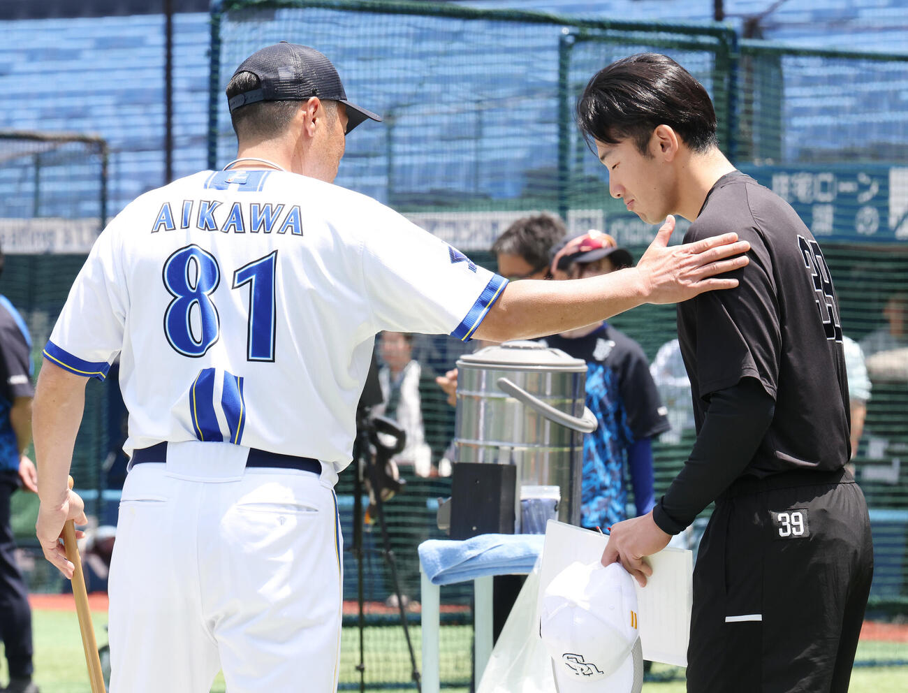 DeNA対ソフトバンク　試合前、ソフトバンク山本祐大（右）の肩をたたくDeNA相川亮二監督（撮影・宮地輝）