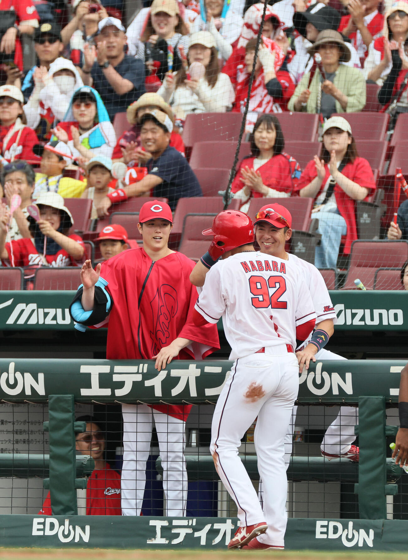 広島対オリックス　8回裏広島2死一、二塁で2点適時三塁打を放った名原典彦を迎える森下暢仁（左）（撮影・加藤孝規）