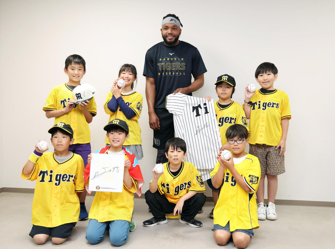こどもたちと記念写真に納まる阪神ラファエル・ドリス（撮影・前田充）＝2026年6月7日