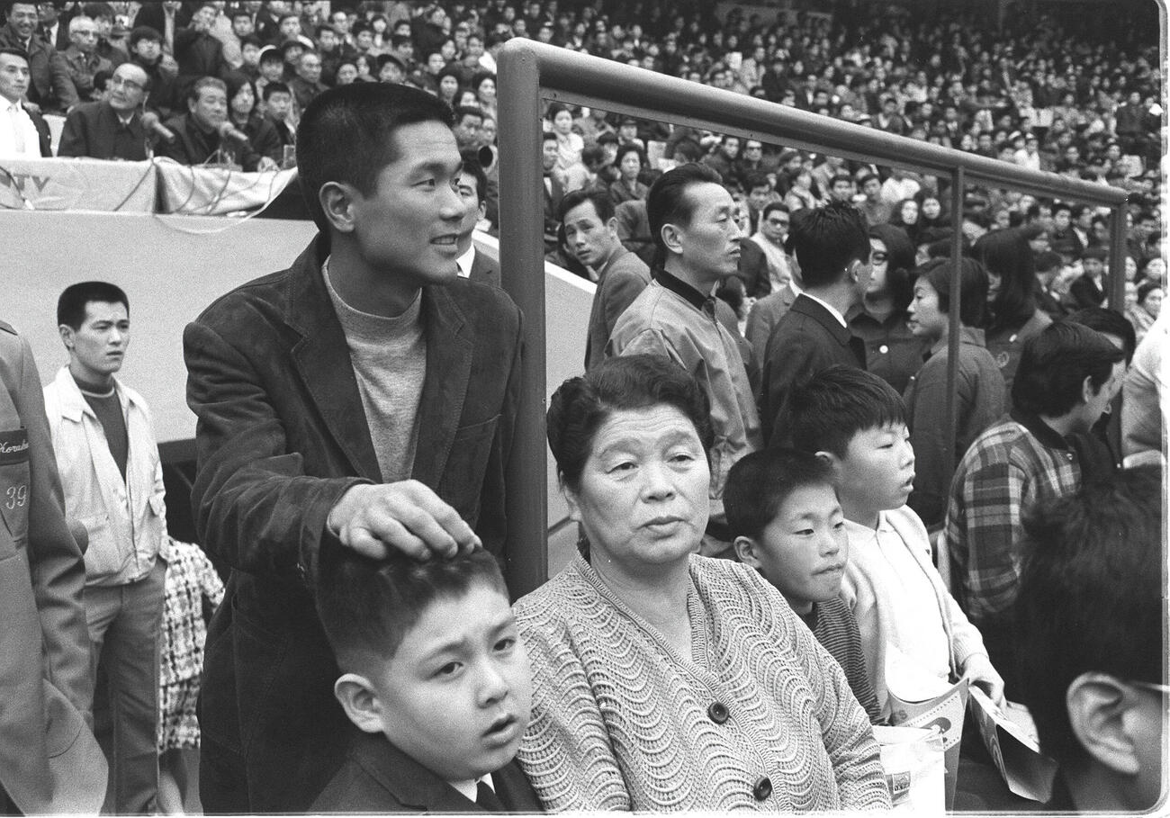 1970年、巨人対ヤクルトオープン戦金田正一の引退試合をネット裏のスタンドで見つめる左から長男の賢一くん、弟の金田留広、母親の君子さん