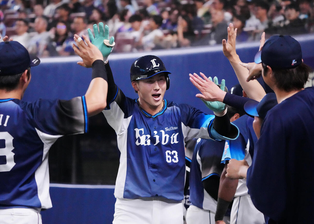 プロ野球交流戦中日対西武　12回表西武無死、長谷川信哉（中央）は本塁打を放ちナインとタッチを交わす（撮影・森本幸一）