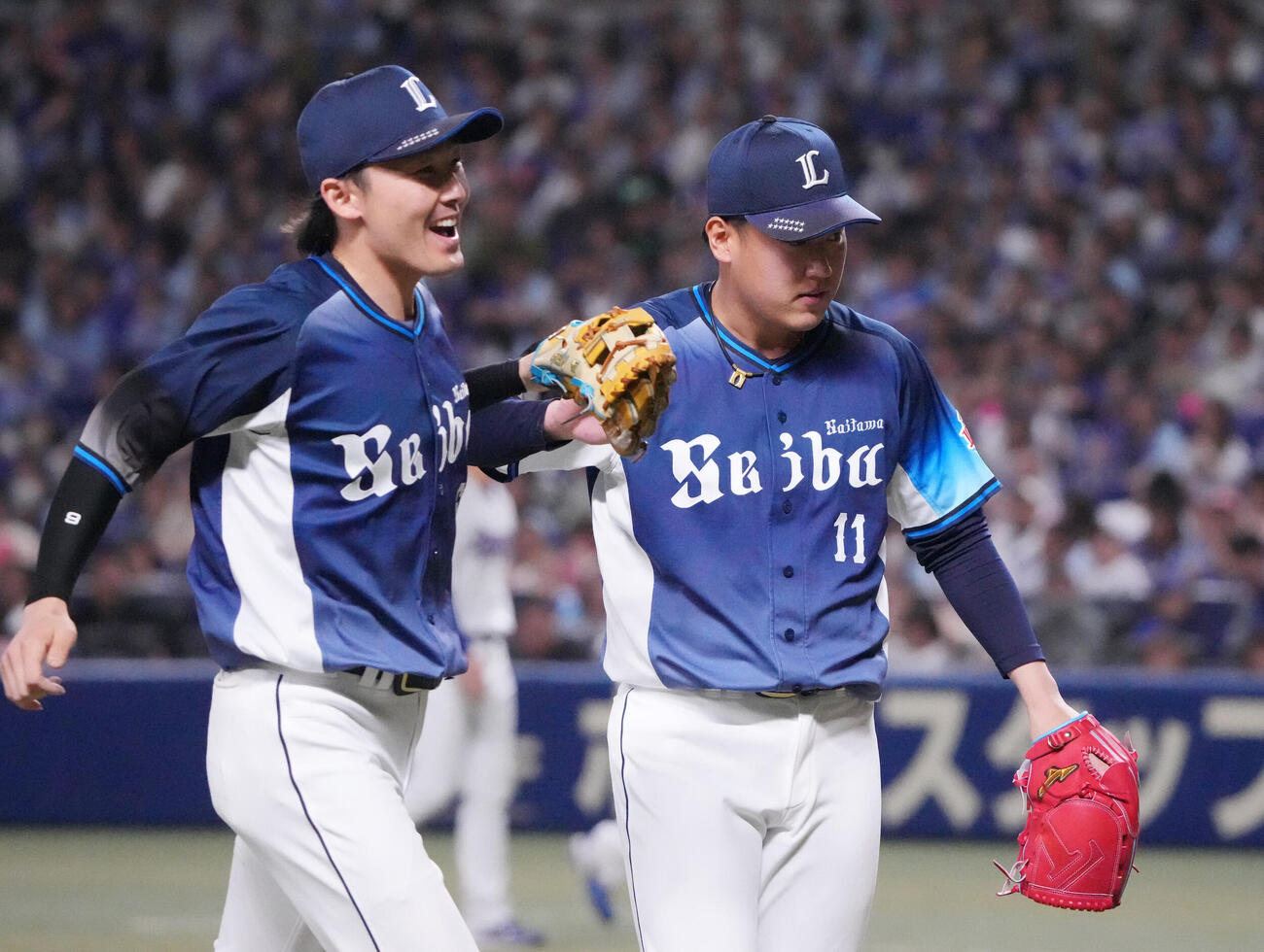 中日対西武　11回裏中日2死満塁、ピンチをしのいだ上田大河（右）は源田壮亮とタッチを交わす（撮影・森本幸一）