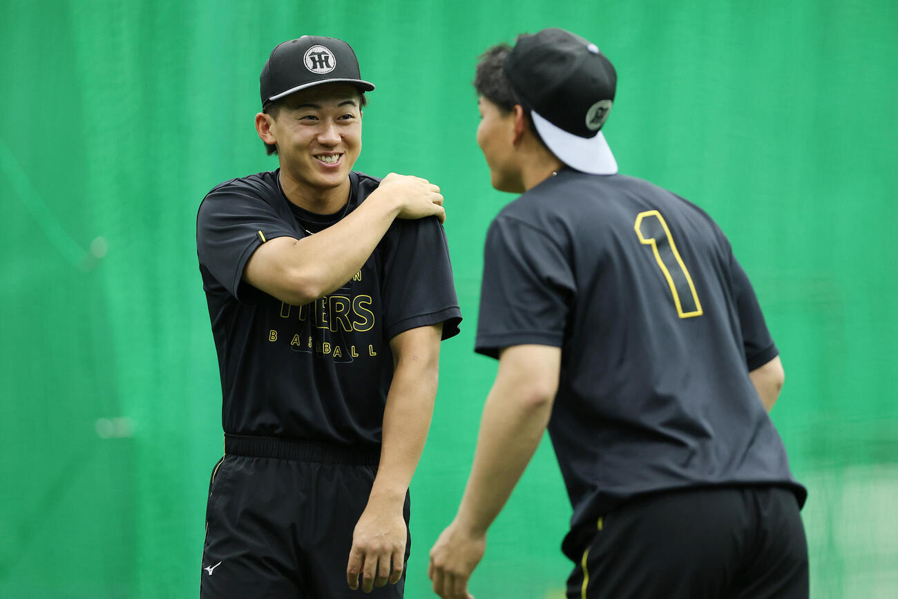 練習前、森下翔太（右）と談笑する阪神立石正広（撮影・前田充）