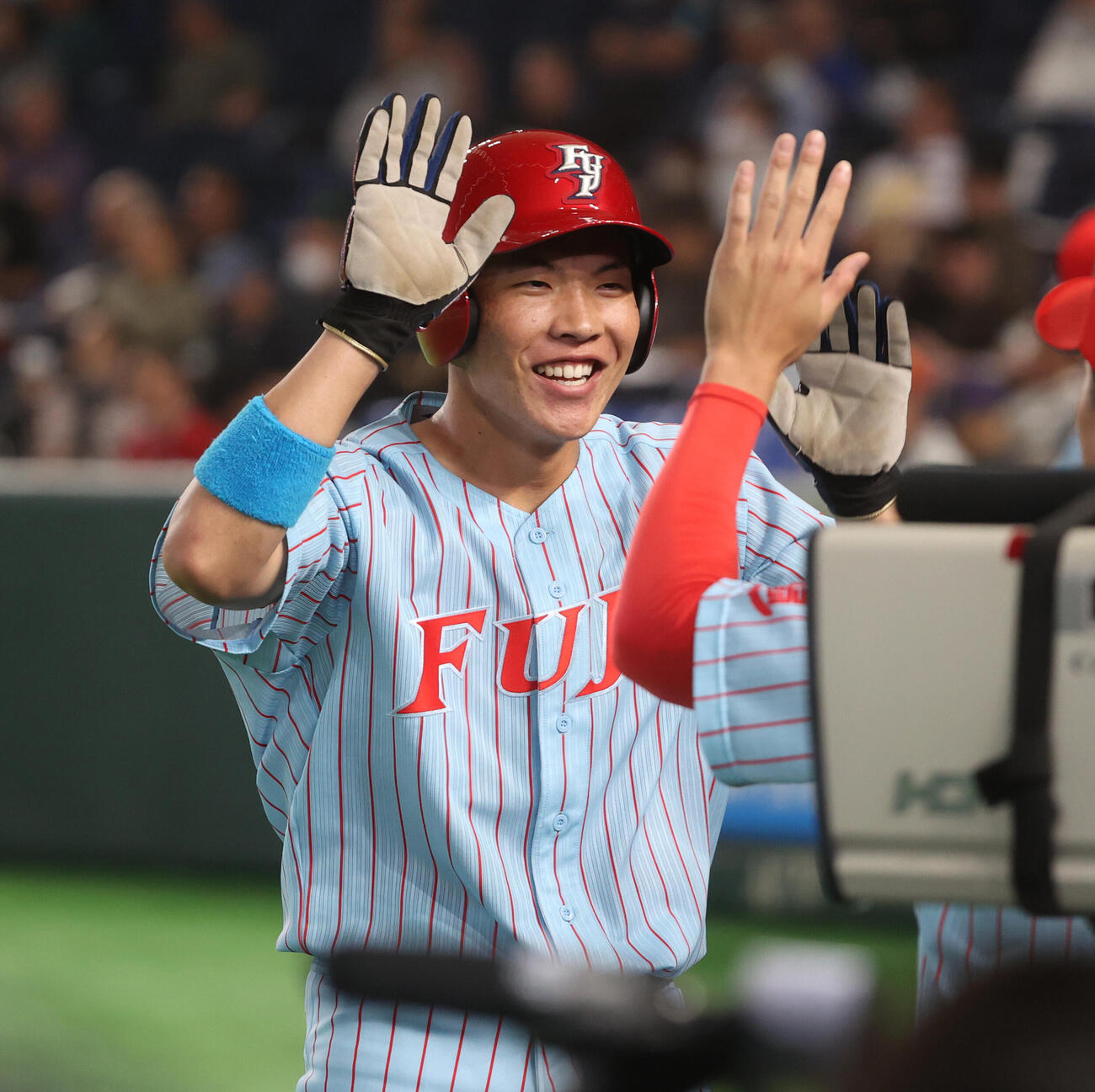 富士大対松山大　2回表富士大2死一、二塁、赤瀬健心の適時打で二塁走者今野正就は生還しナインとハイタッチする（撮影・柴田隆二）