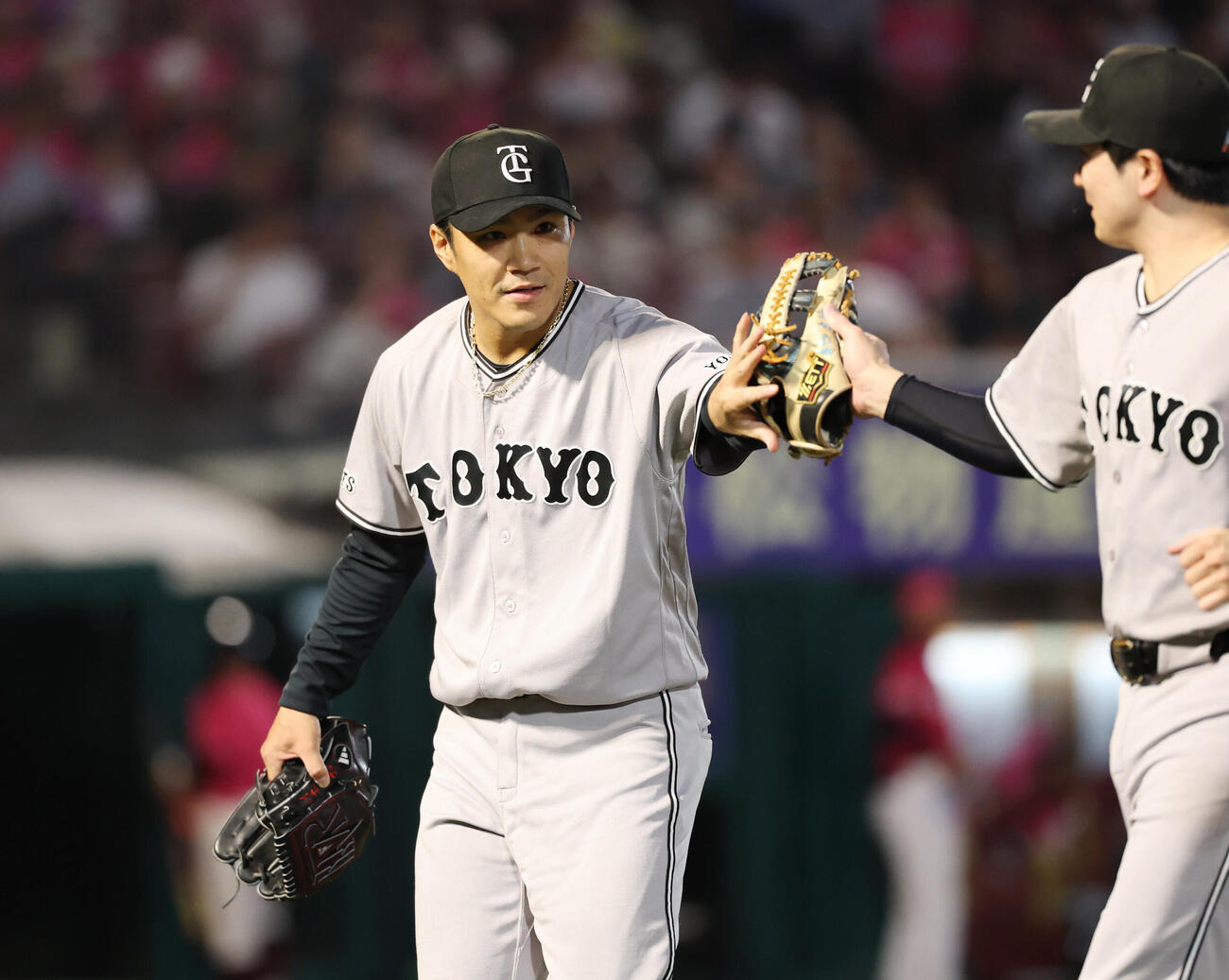 楽天対巨人　4回裏を終え、泉口友汰（右）とタッチ交わす則本昂大（撮影・増田悦実）